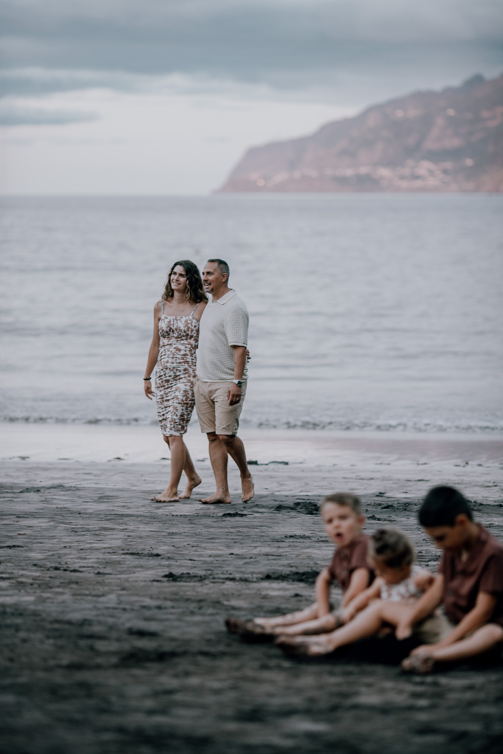 Mum and dad walking the beach as the kids dig, Seixal Beach, Madeira