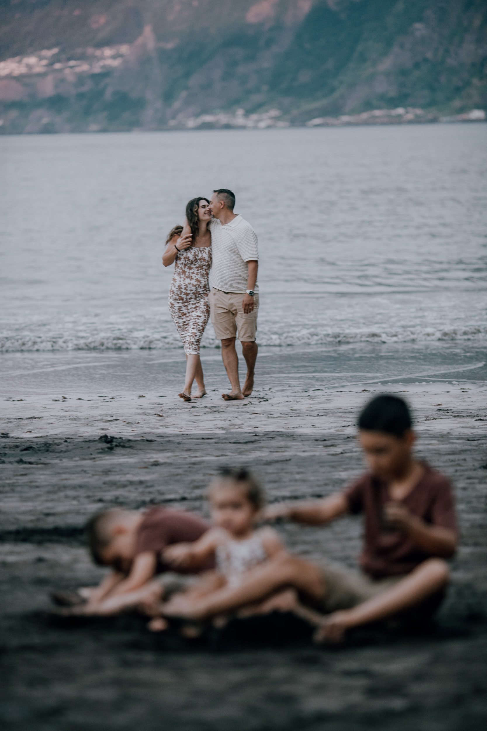 Parents arm in arm behind the playing children, Seixal, Madeira