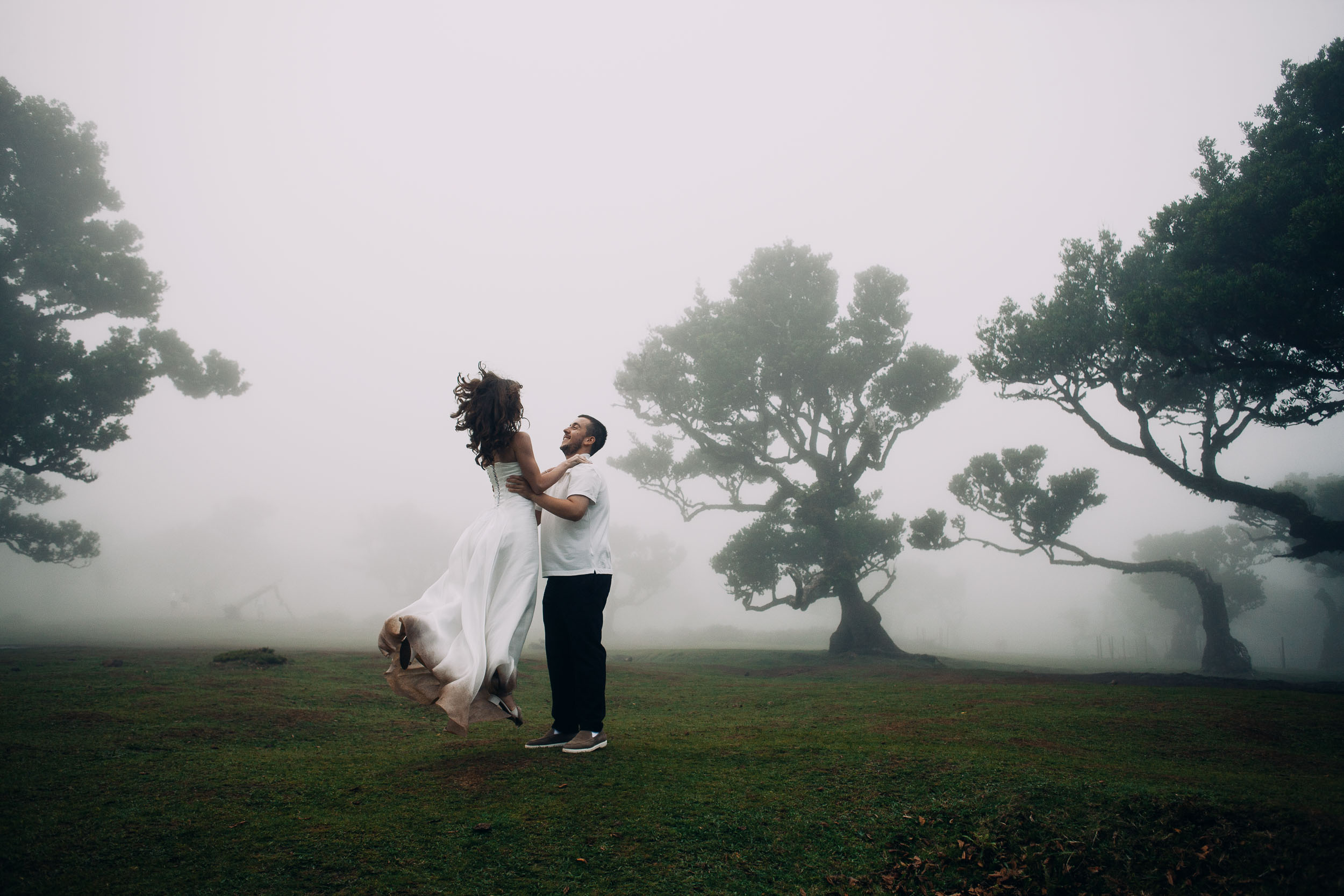 Long white dress lifting as he turns her under his arm in the still wet air of the laurel forest, Fanal Forest, Madeira