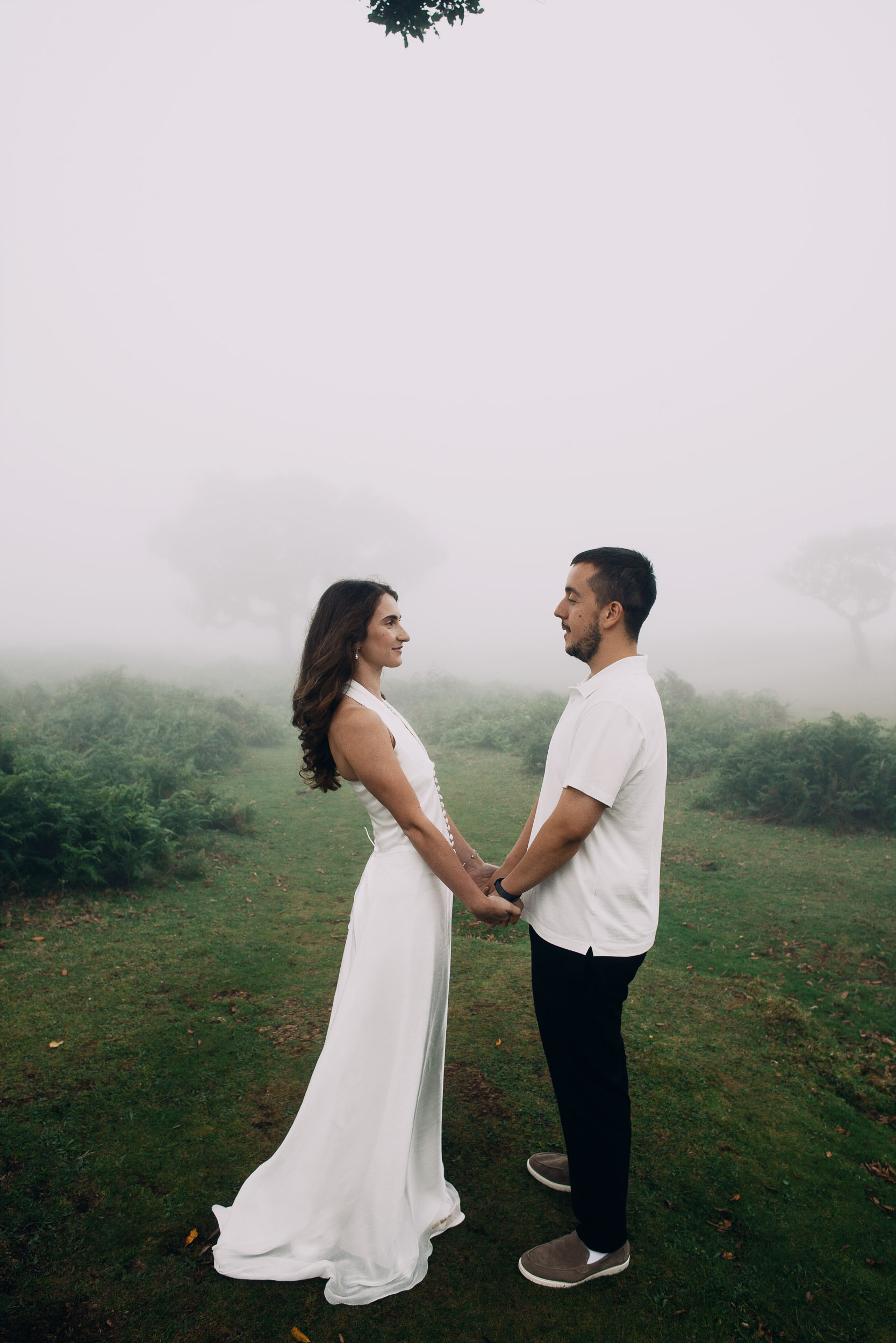 Couple facing each other holding both hands on the open plateau, Fanal Forest, Madeira