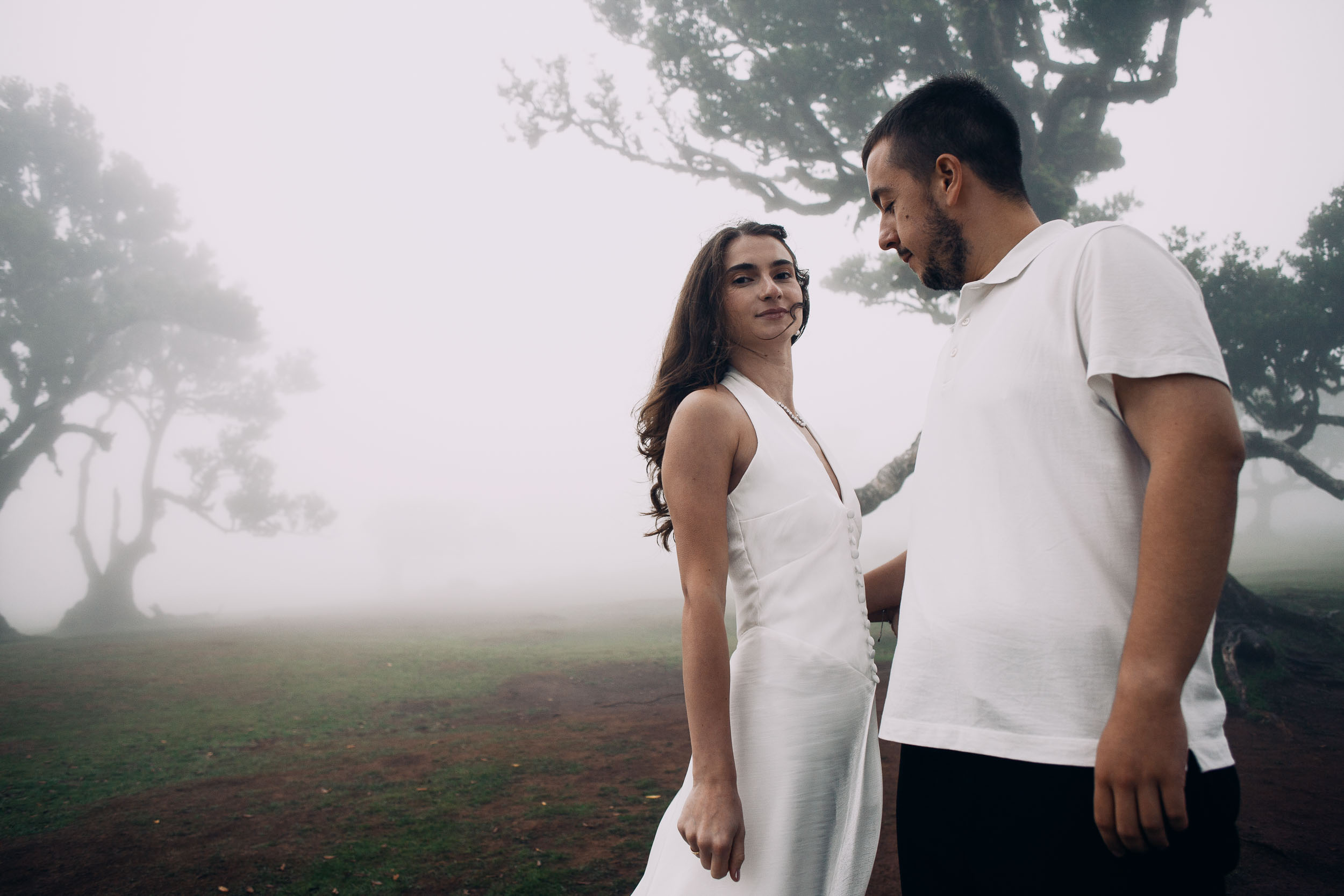 She looks over her shoulder at the camera while he looks down at her, Fanal Forest, Madeira
