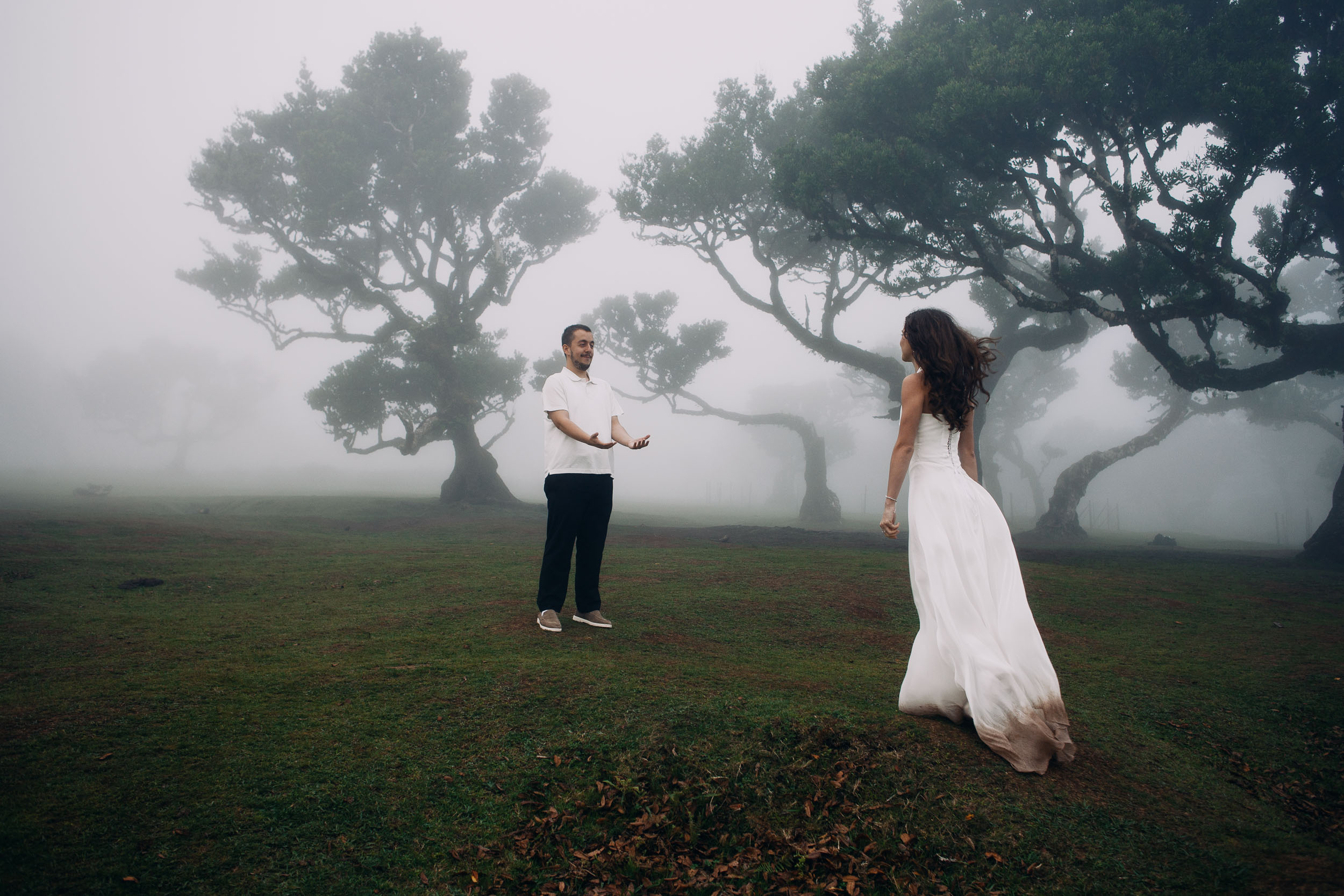 Wide frame of her walking toward him across the plateau, Fanal Forest, Madeira