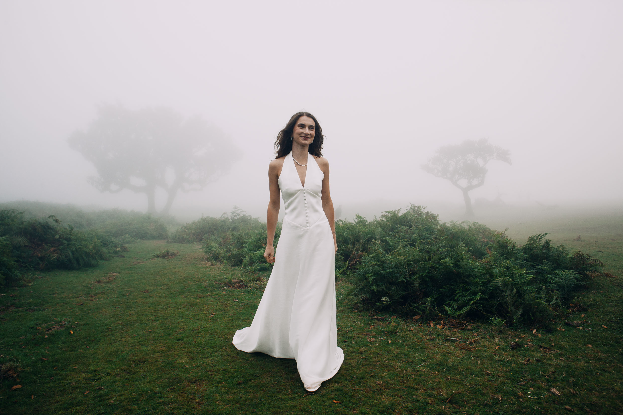 Woman walking toward the camera through ferns and mist, Fanal Forest, Madeira