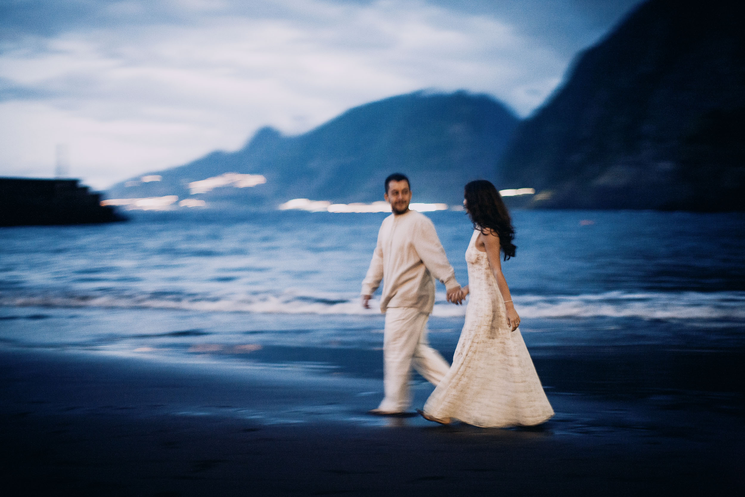 Couple walking barefoot along the waterline at blue hour, Seixal Beach, Madeira
