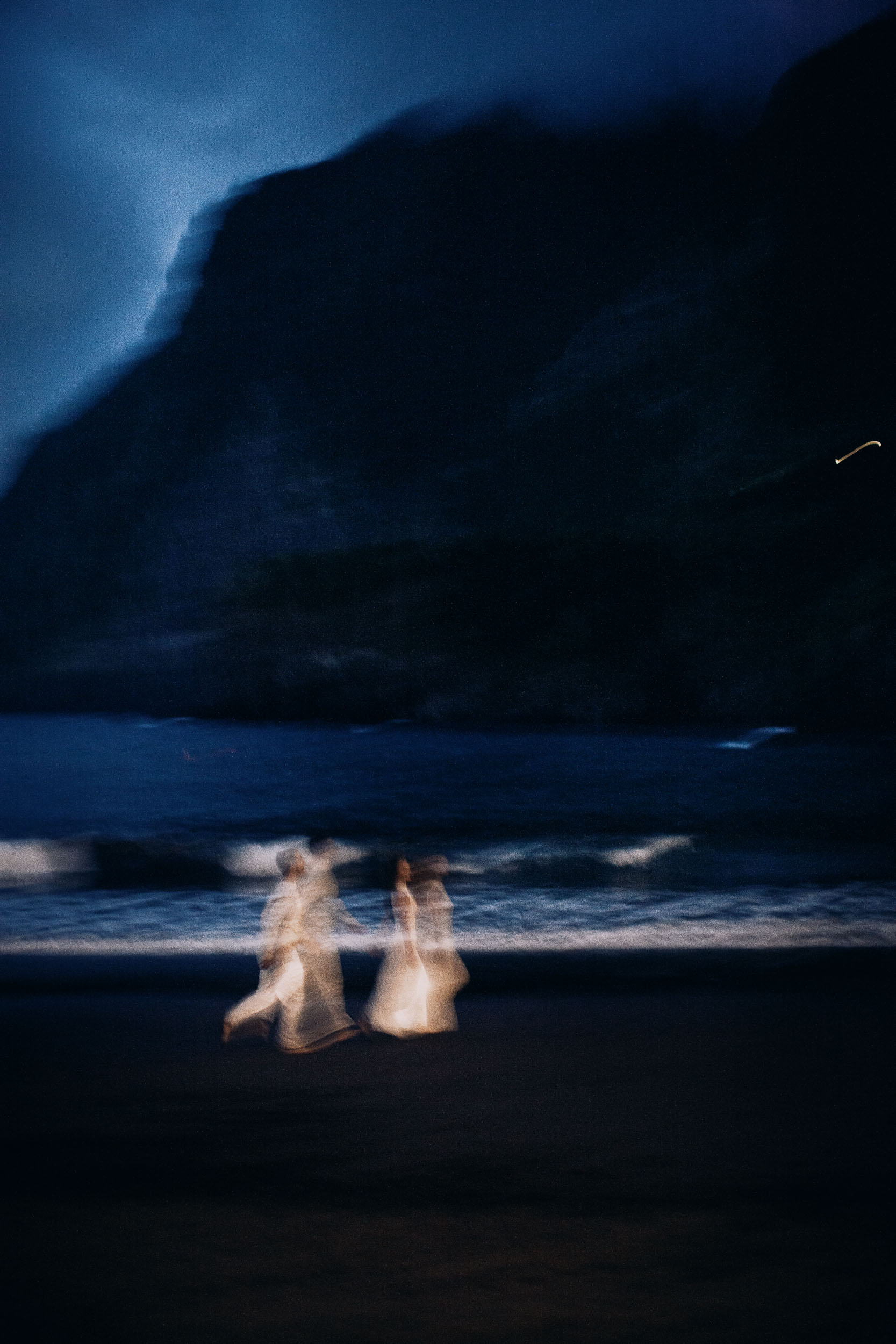 Two figures at the edge of the water as the sky goes out, Seixal Beach, Madeira