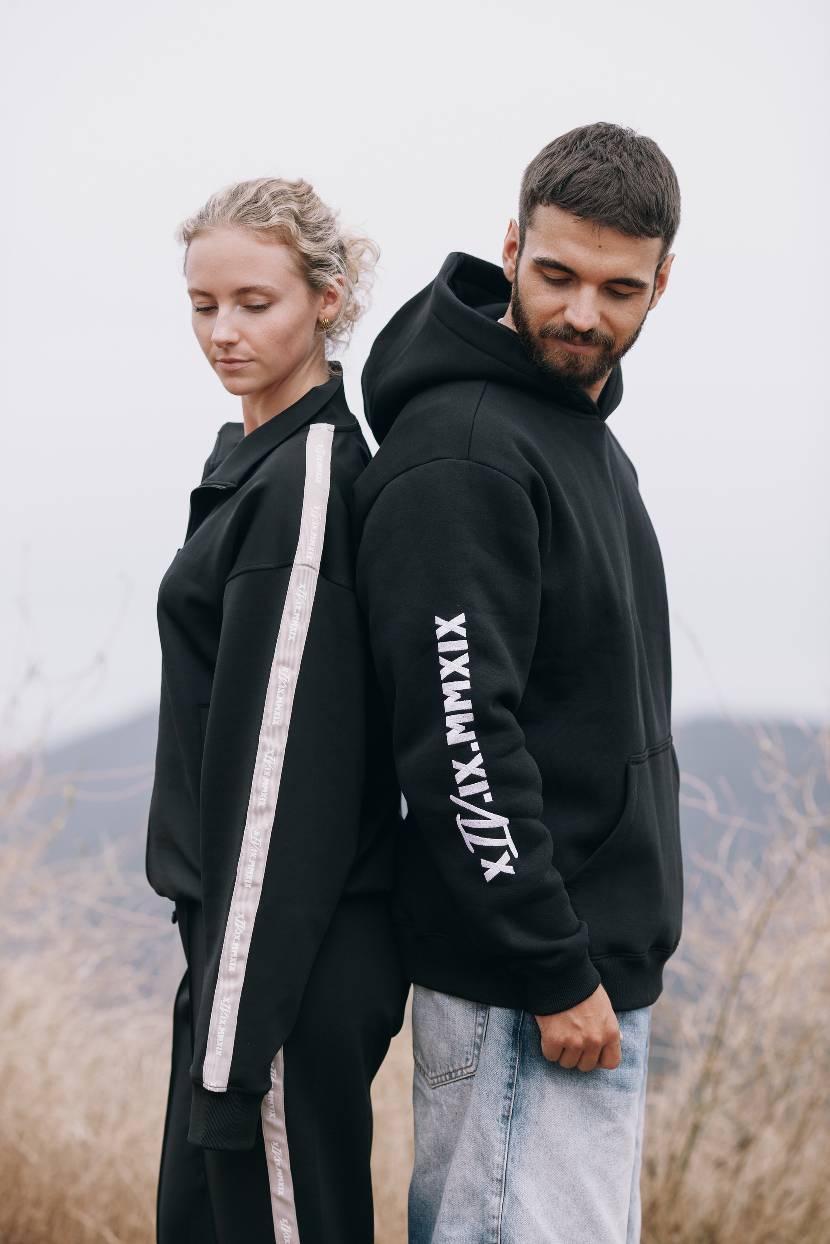 Two models back to back, the roman numeral print running down the hoodie sleeve, Madeira highlands