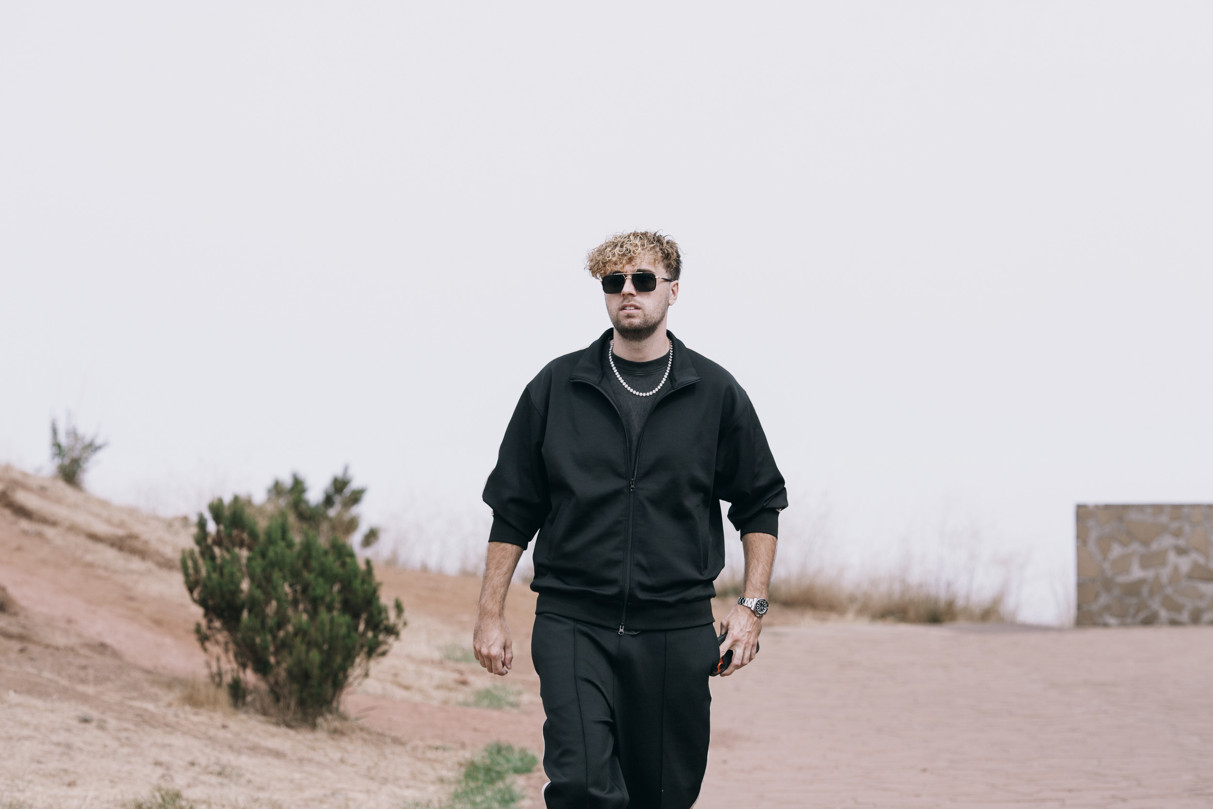 Man in black walking along a dirt path at the viewpoint, Madeira highlands
