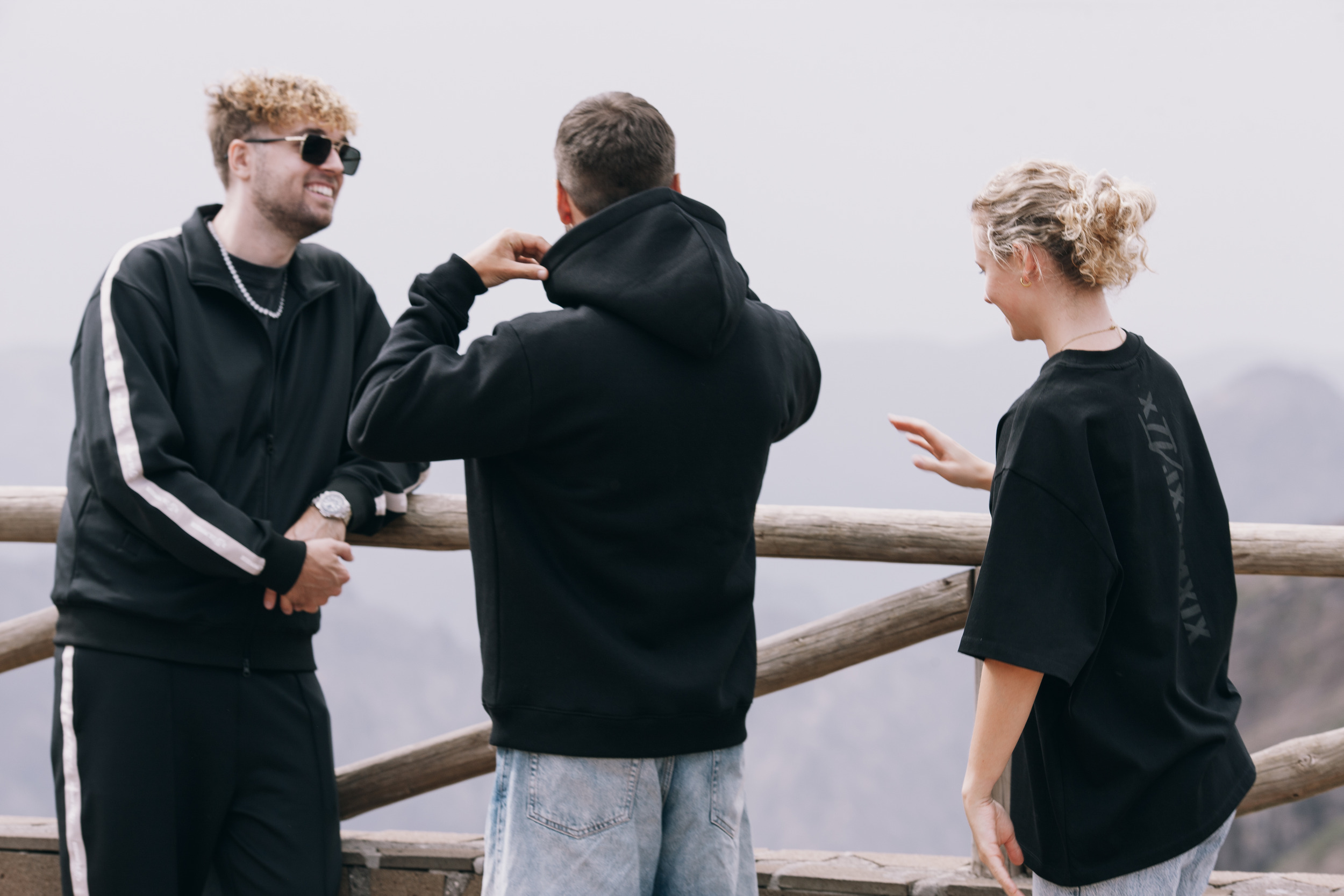 Three models at the wooden railing above the ridge, Madeira highlands