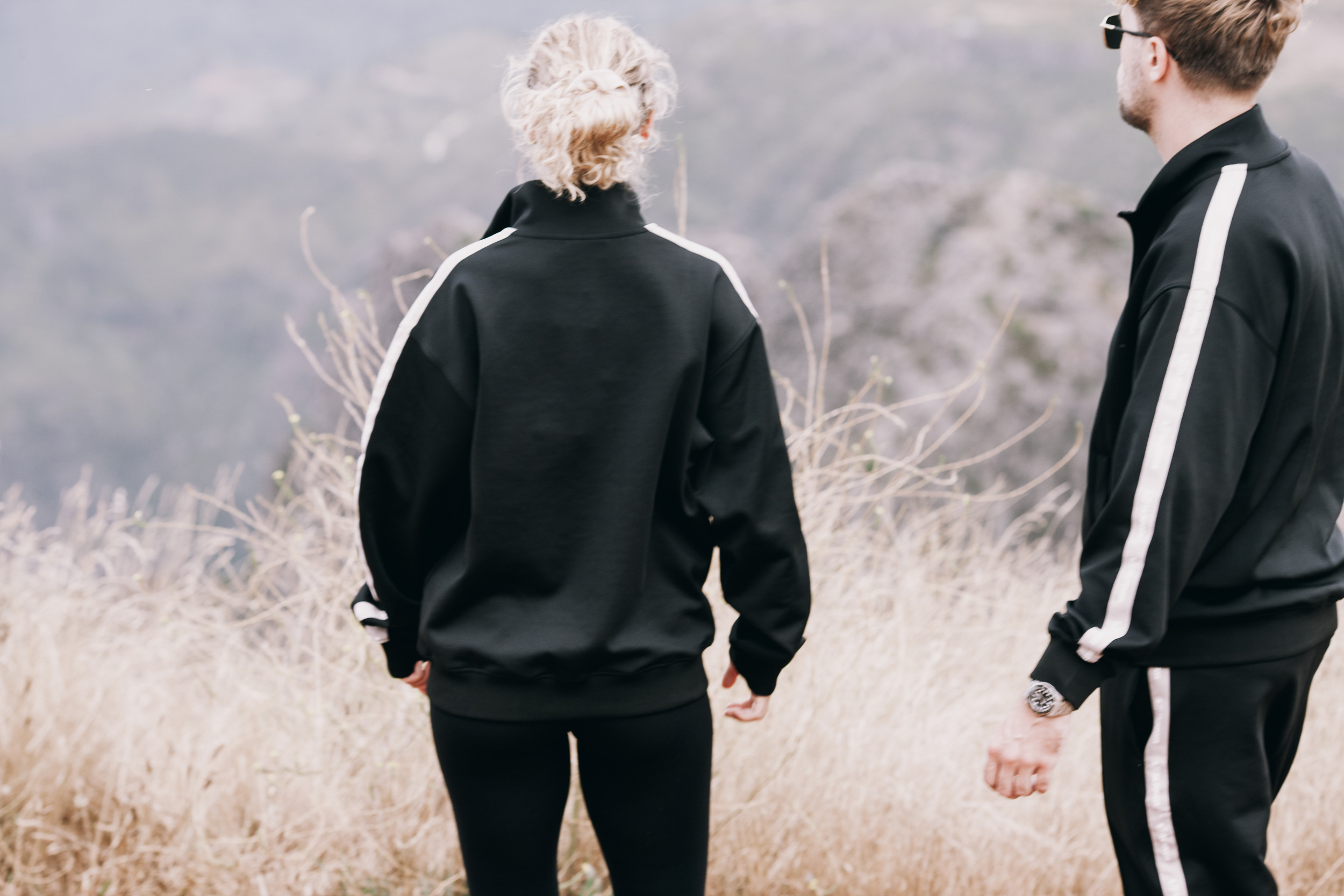 Pair seen from behind in track jackets, stripes running down both sleeves, Madeira highlands