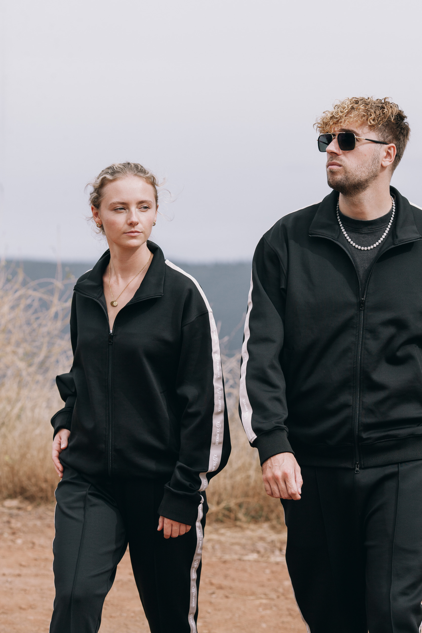 Pair in track suits looking at the camera, hazy ridge behind, Madeira
