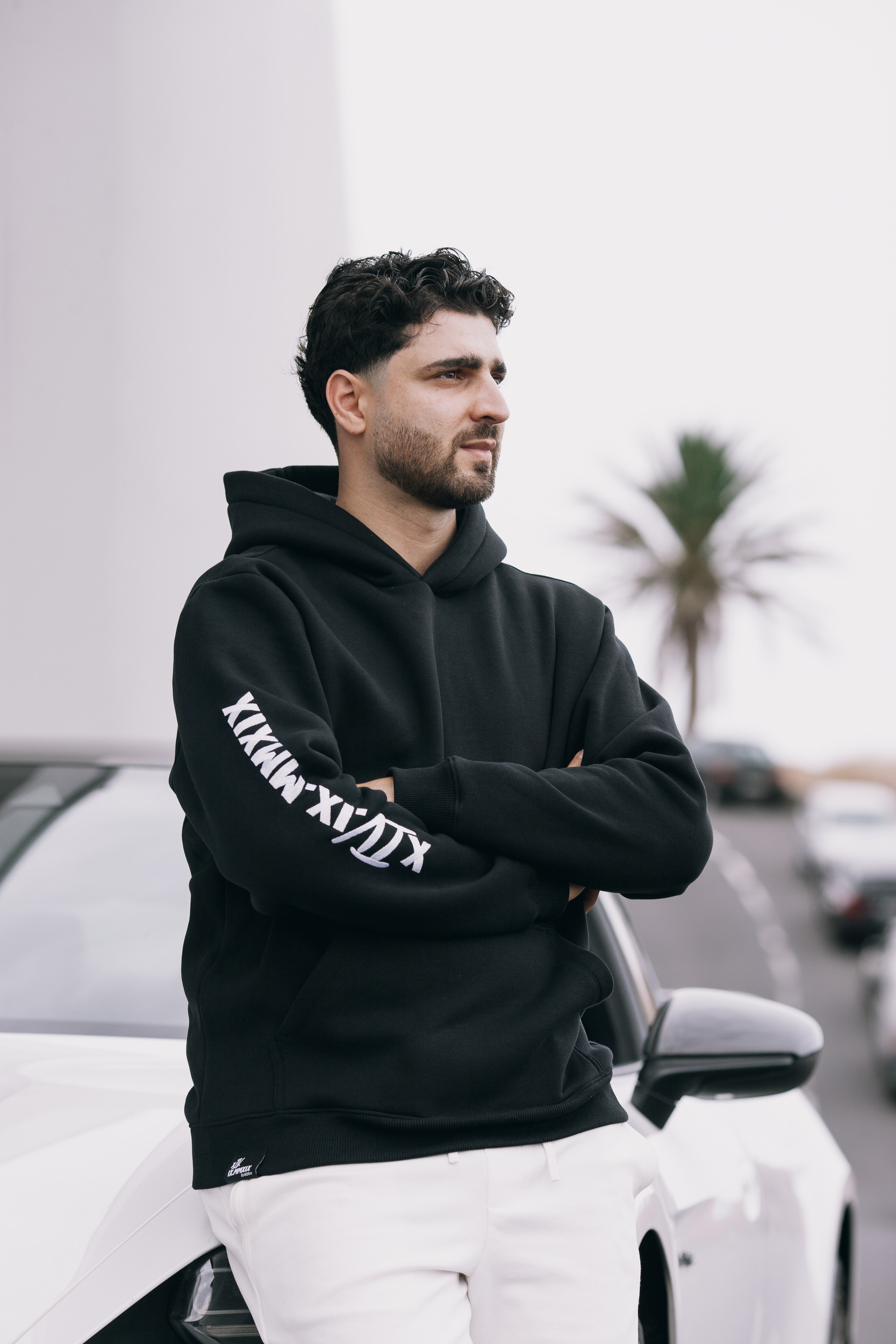 Three quarter view of the hoodie sleeve print beside the white car, Madeira