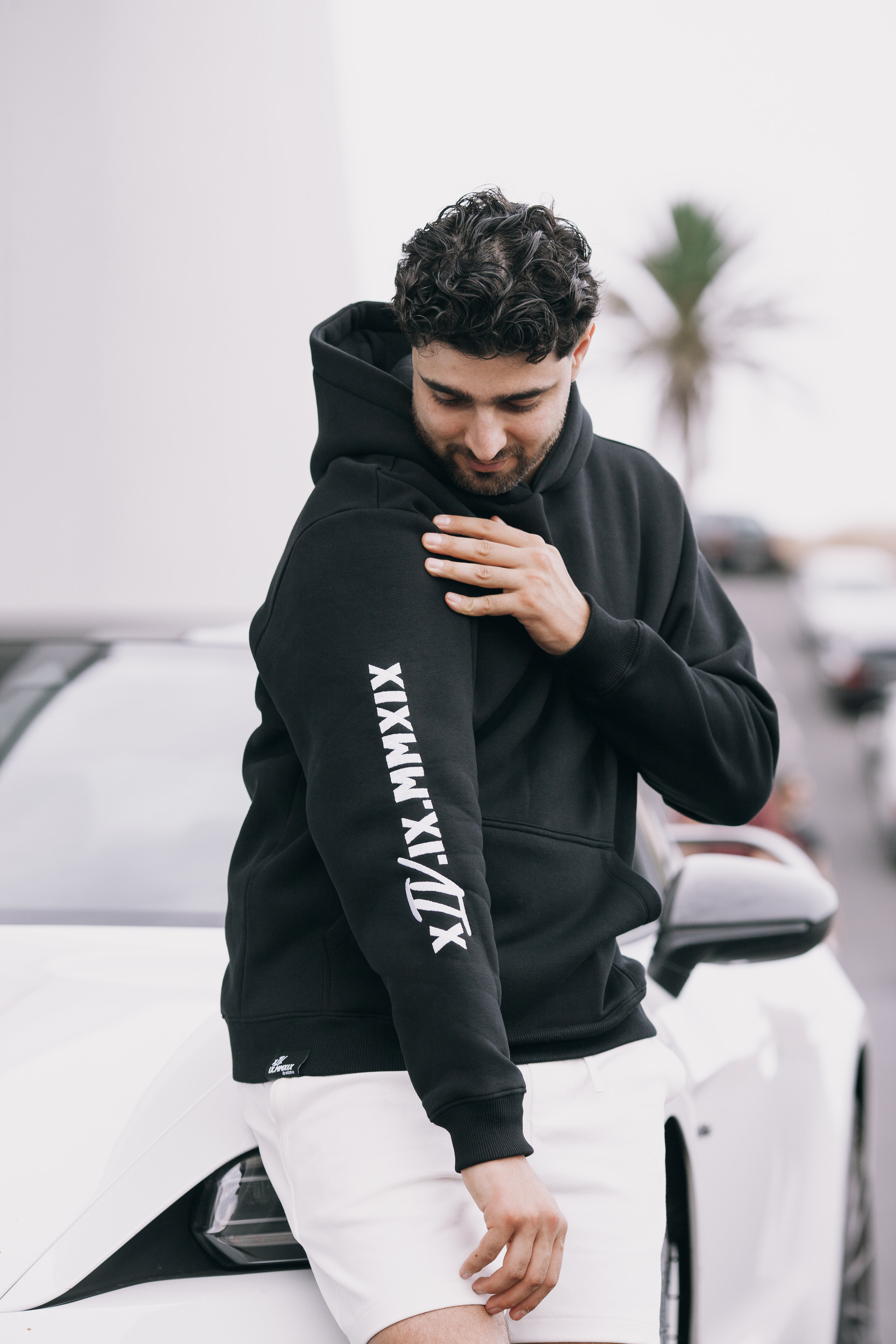 Man leaning on the white sports car in the black hoodie, Madeira