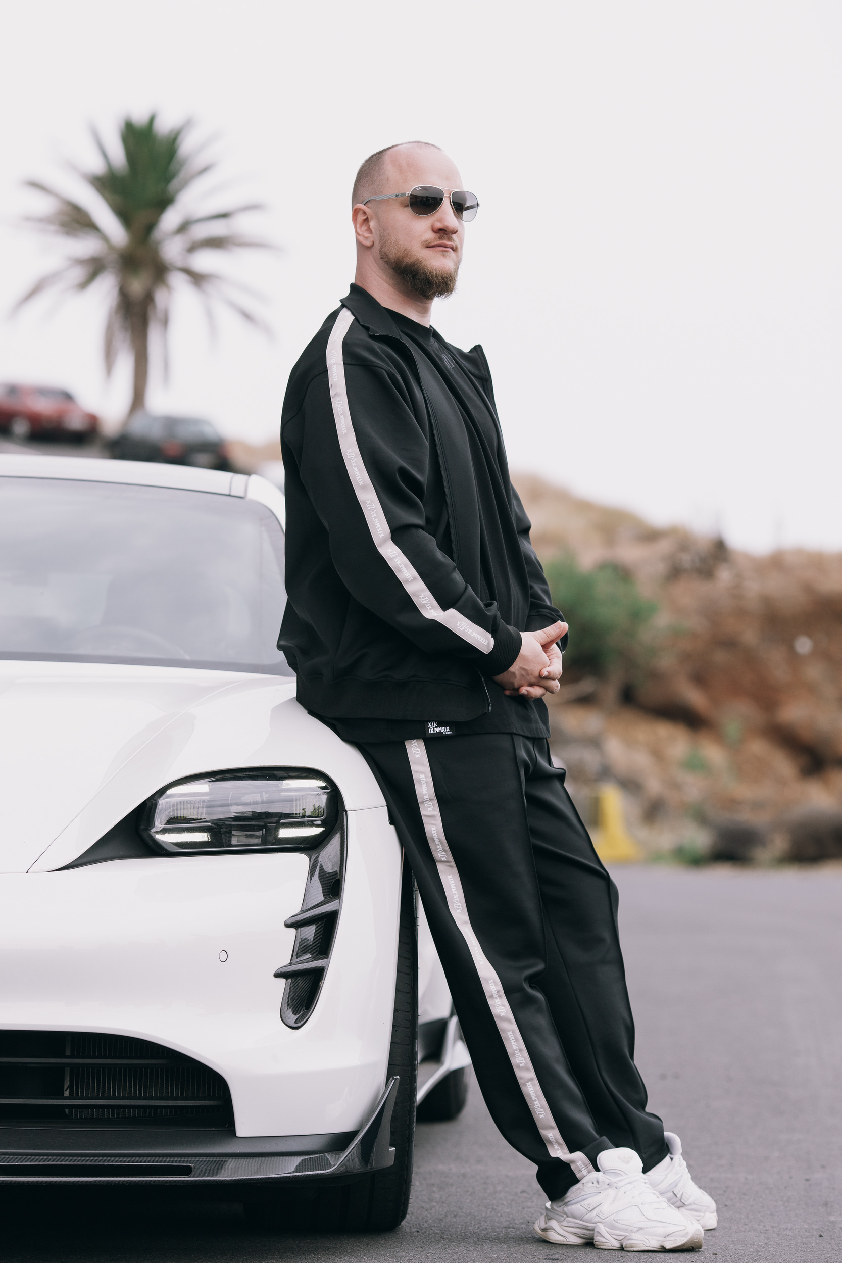 Man in the black track suit standing by the white sports car, Madeira