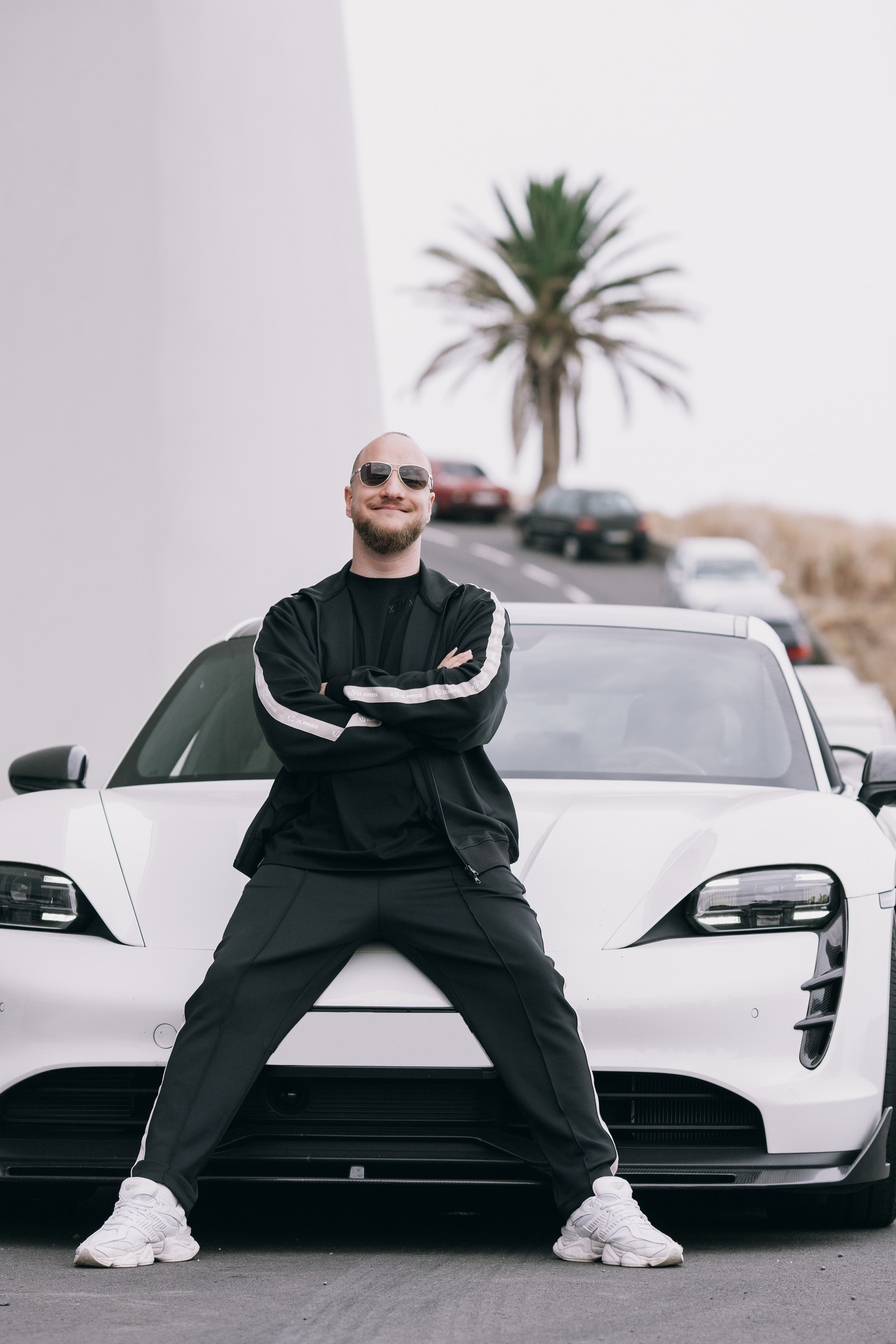 Man in the track suit with arms crossed in front of the white car, Madeira