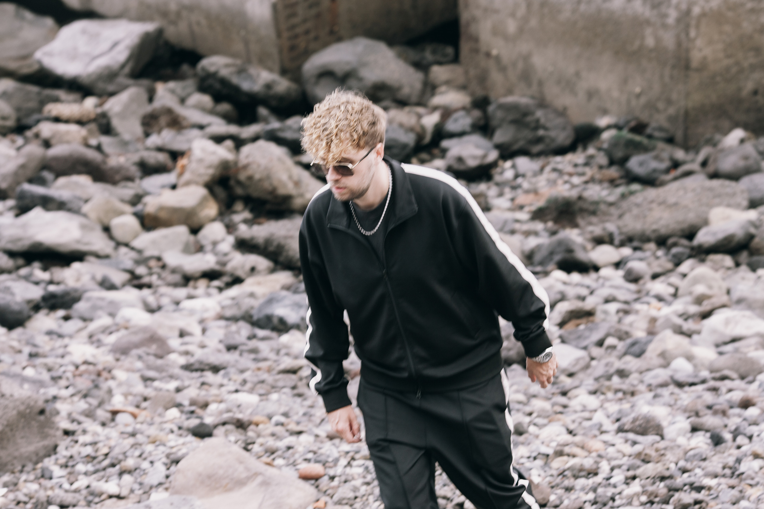 Model walking across the volcanic rocks under the runway, Madeira