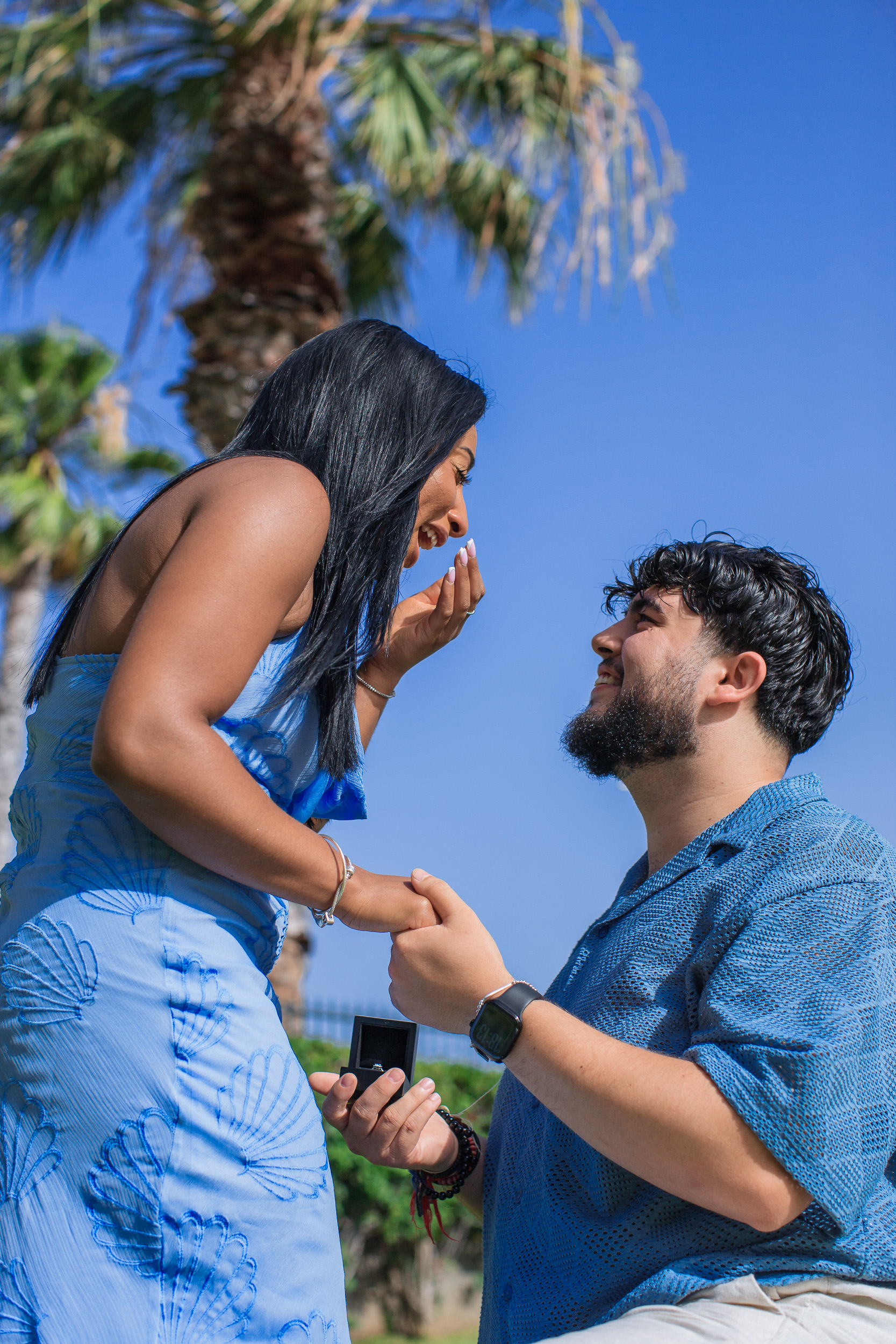 Hand over her mouth as he takes her hand with the ring, central Funchal, Madeira