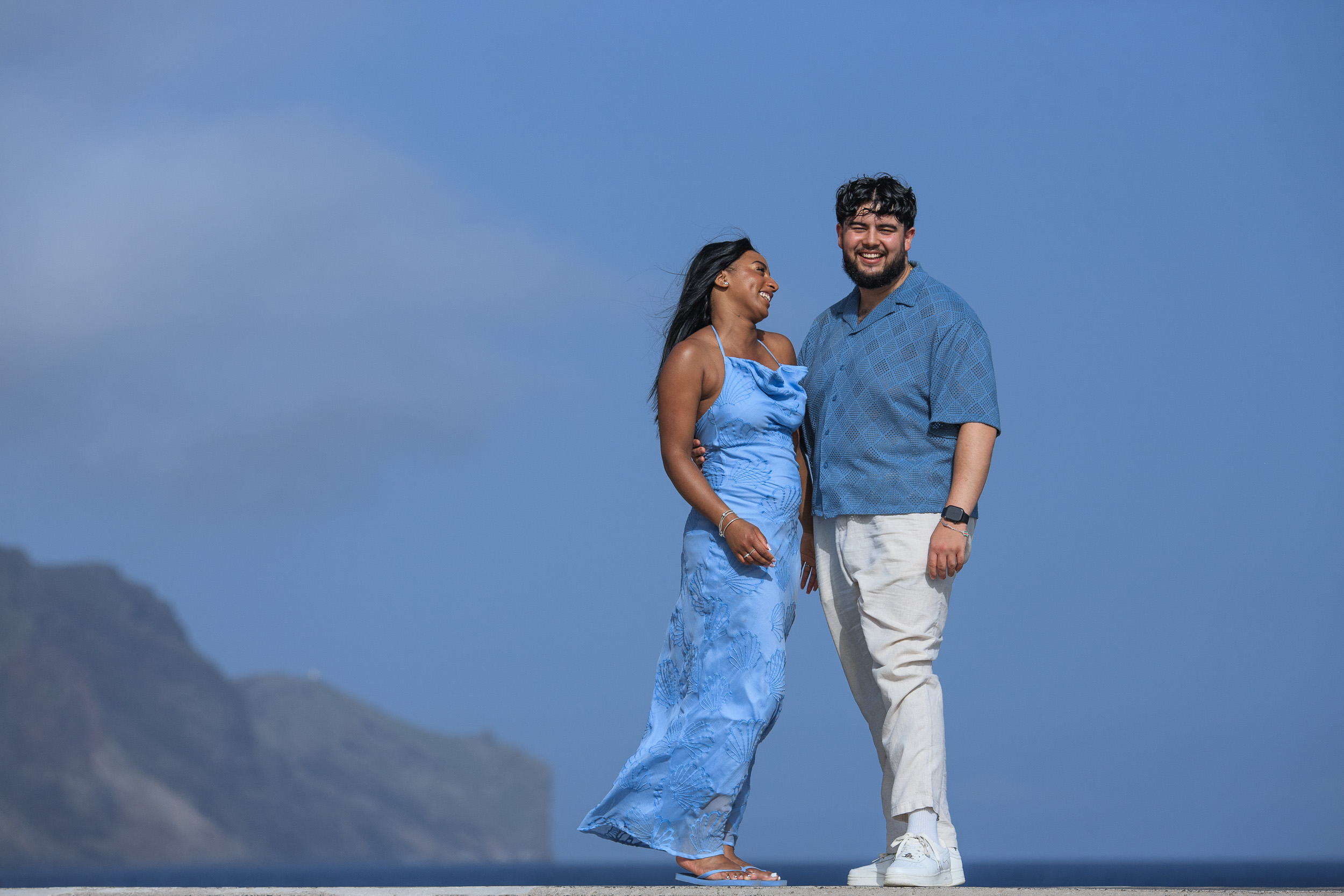 Standing together on the seafront wall, the eastern cliffs of Funchal behind, Madeira