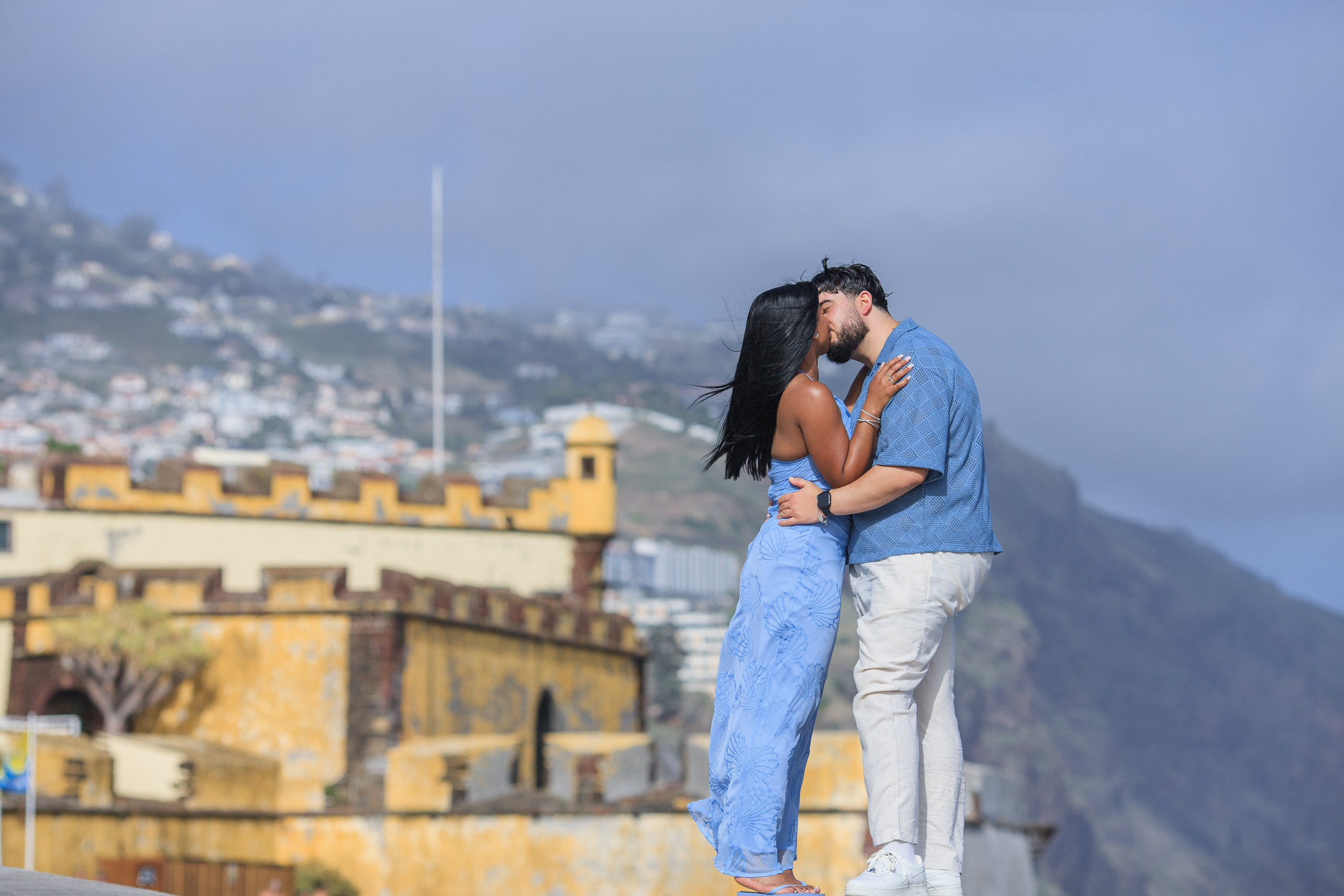 Kissing above the yellow walls of Forte de Sao Tiago, Funchal old town, Madeira