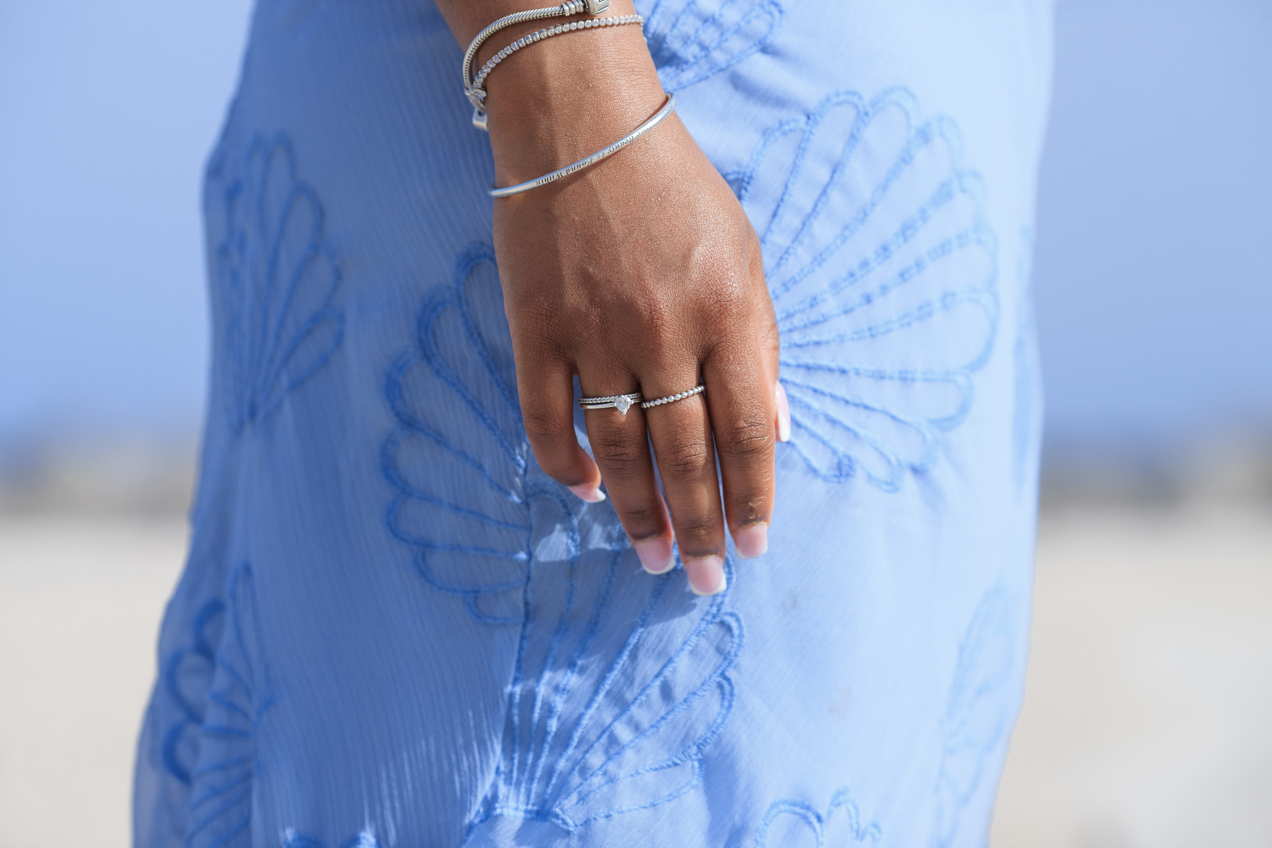 Detail of her hands and rings against the blue dress, engagement in Funchal, Madeira
