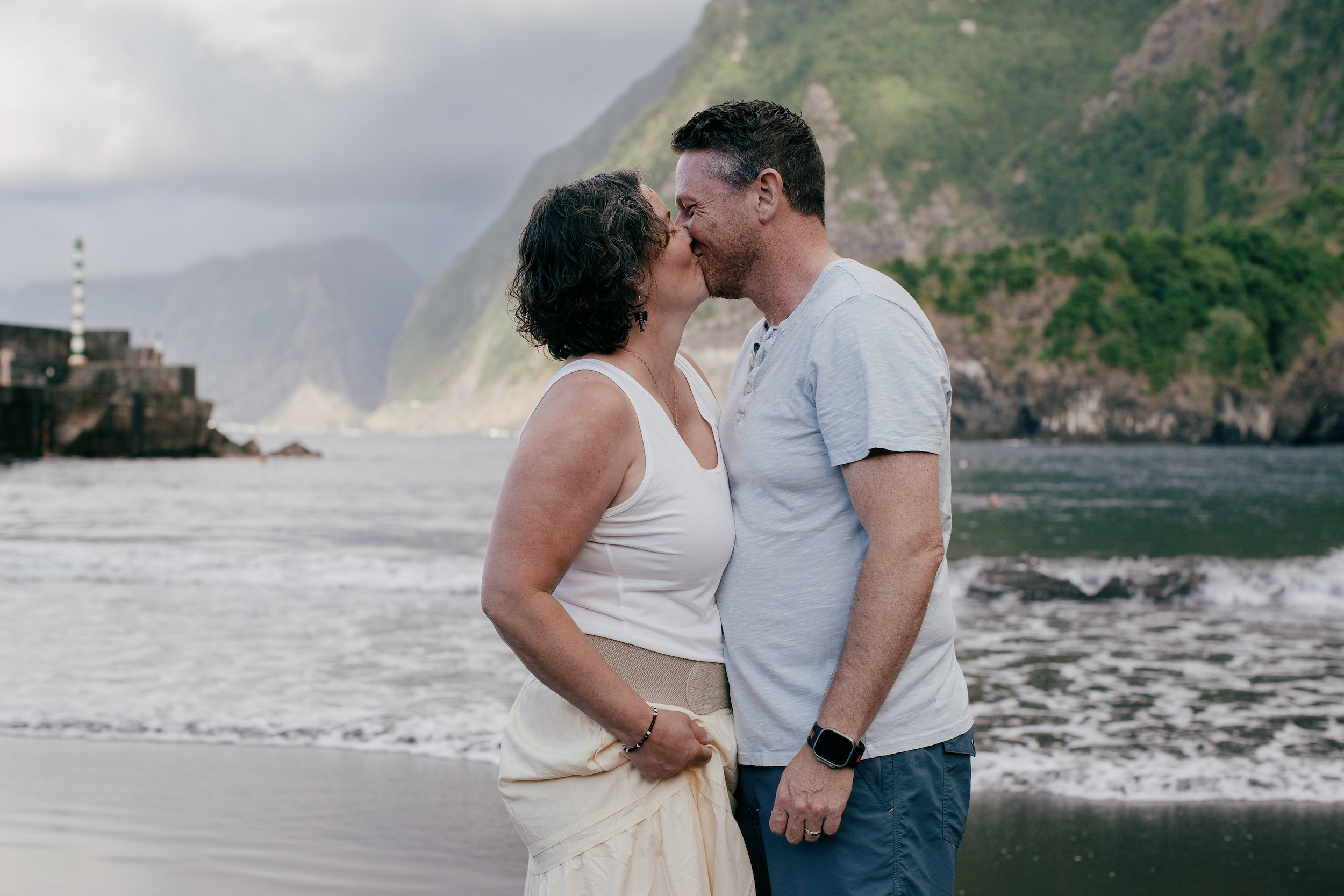 A kiss between the parents on the black sand at Seixal Beach, Madeira