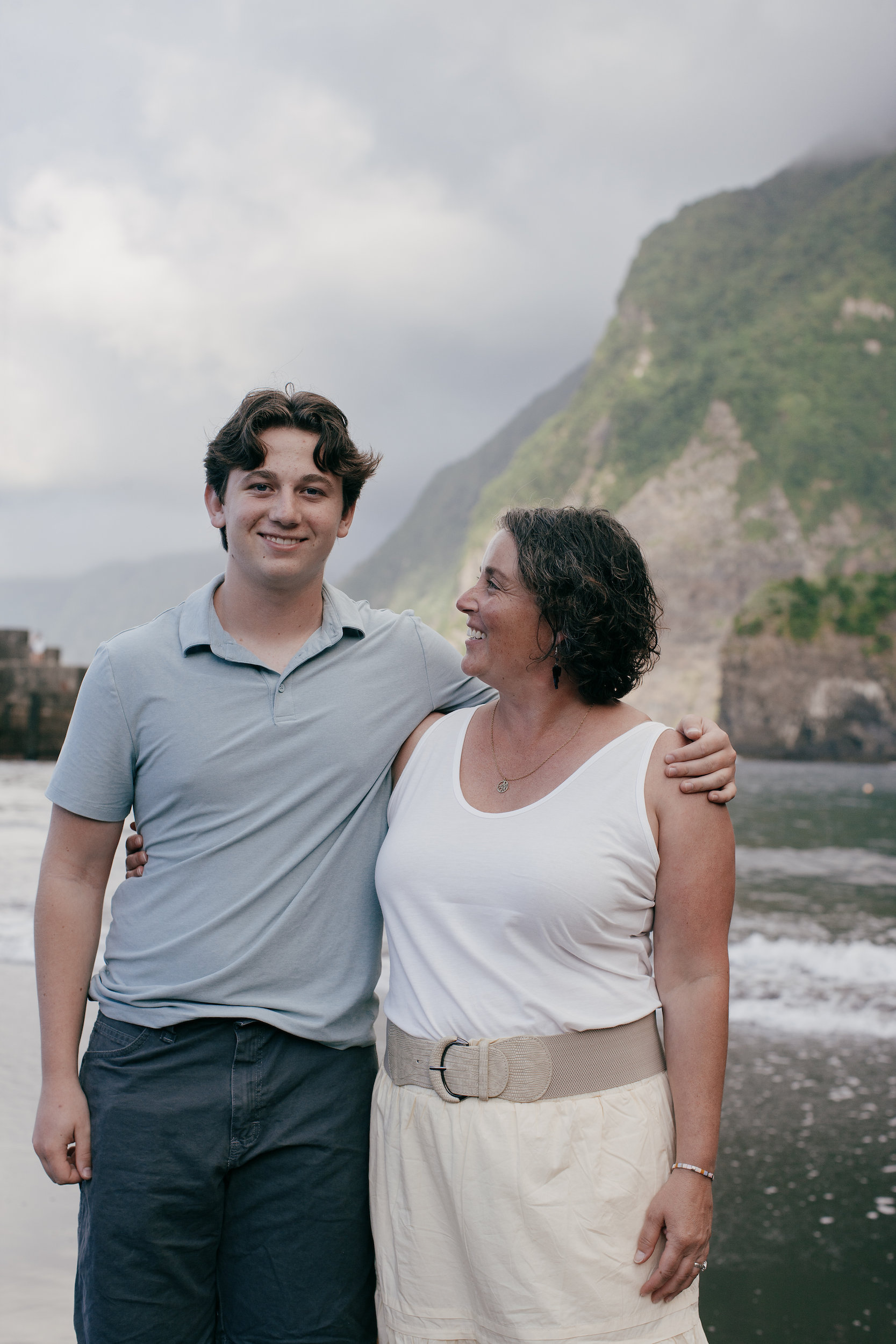 Teenage son with his mother by the sea wall at Seixal, Madeira