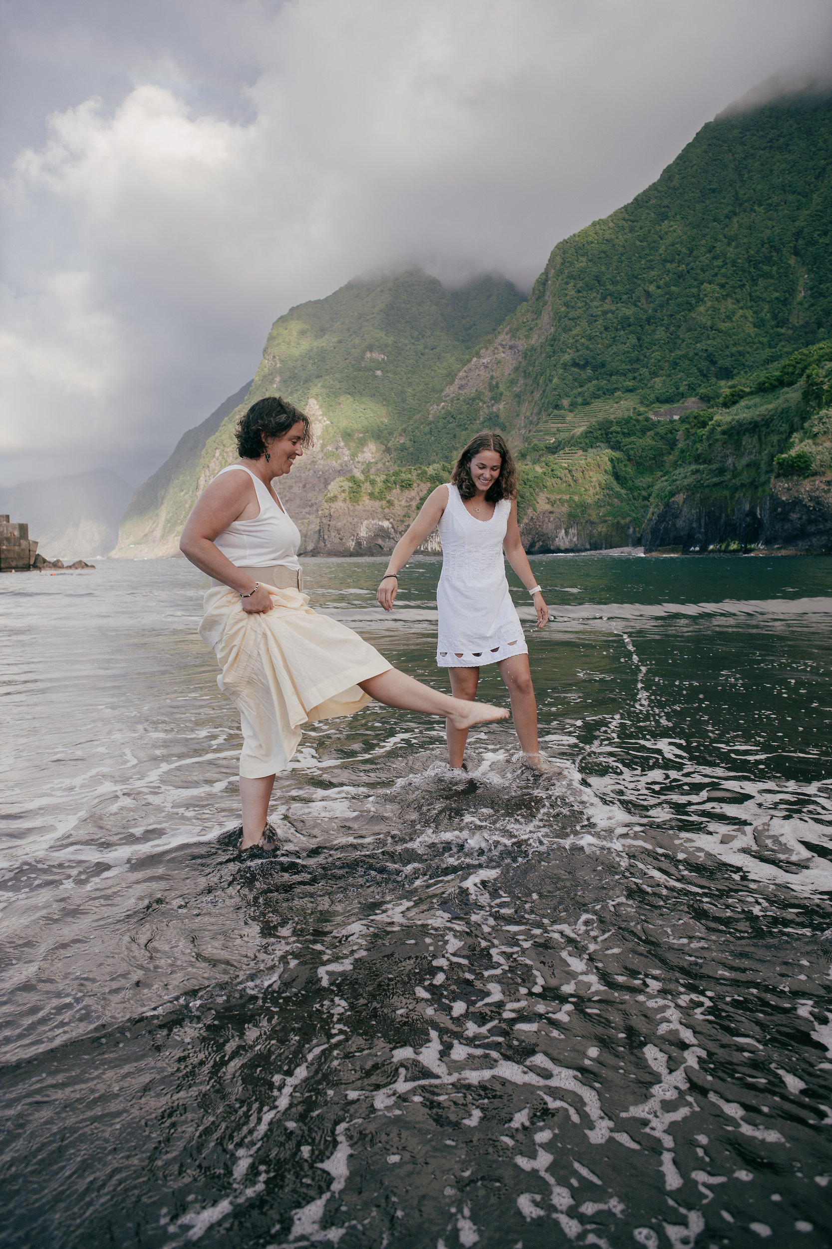 Mother and daughter kicking water at each other, Seixal Beach, Madeira