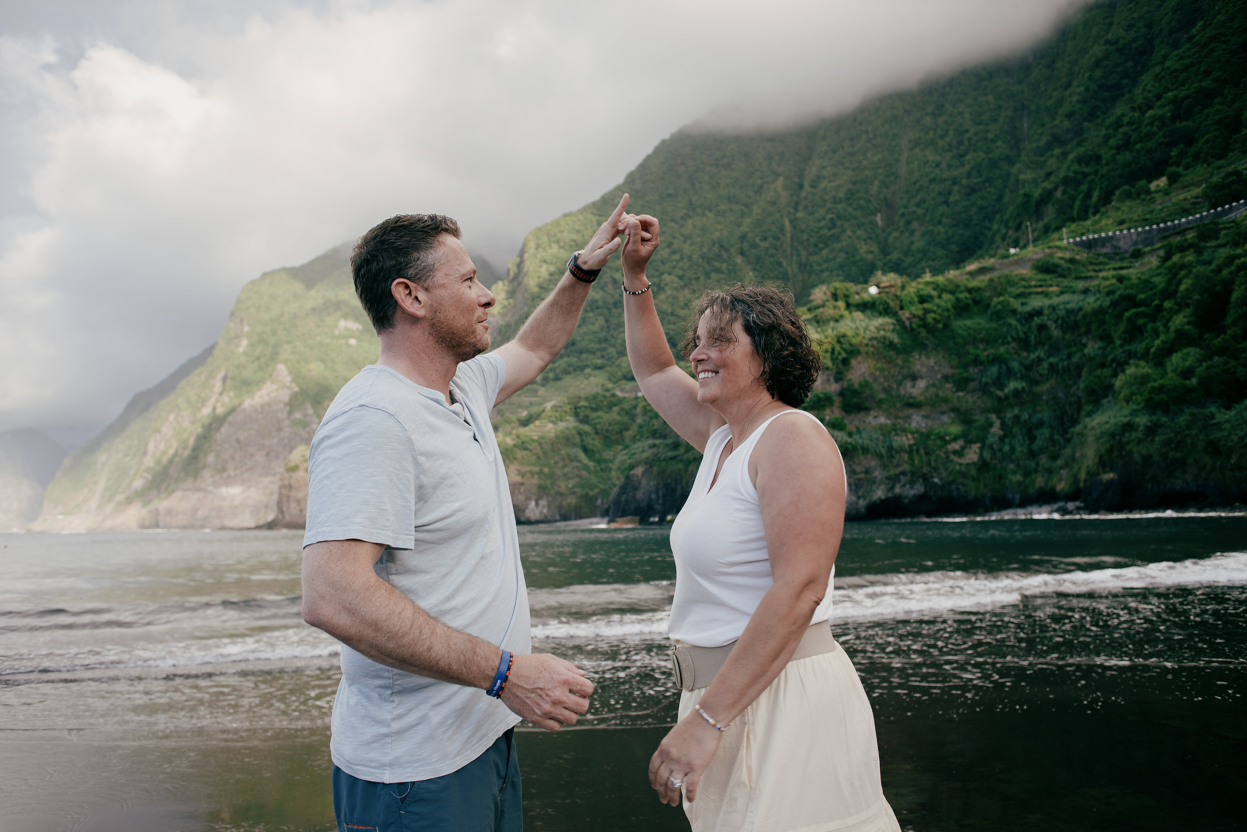 Parents joining hands on the mirror-wet sand, Seixal, Madeira