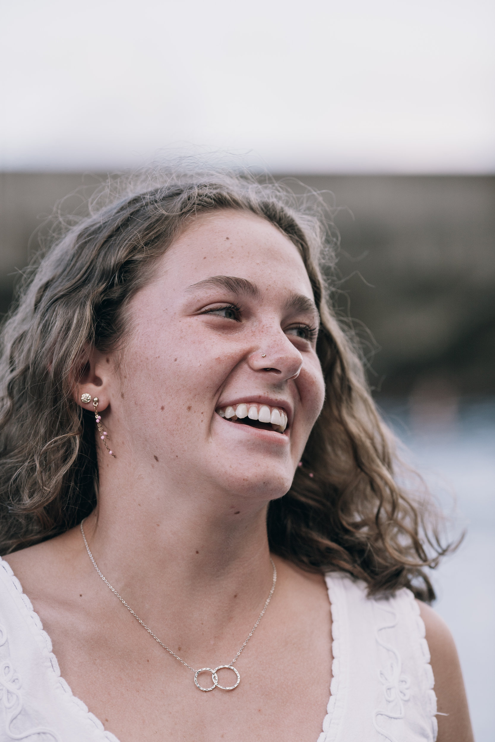 The daughter laughing, curls loose, on the beach at Seixal, Madeira