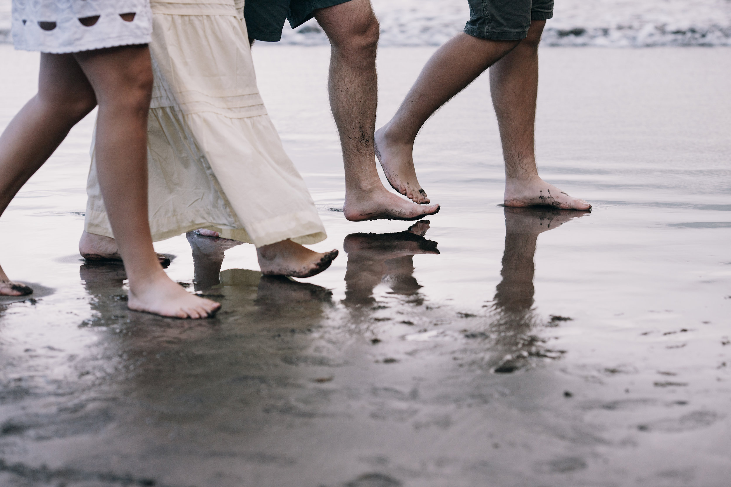 Feet at the waterline as the family wades together, Seixal, Madeira