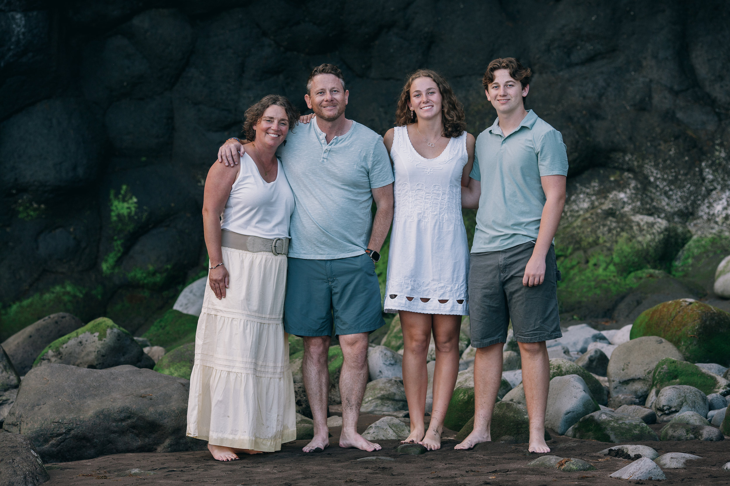 Family portrait against the dark volcanic rocks at Seixal, Madeira