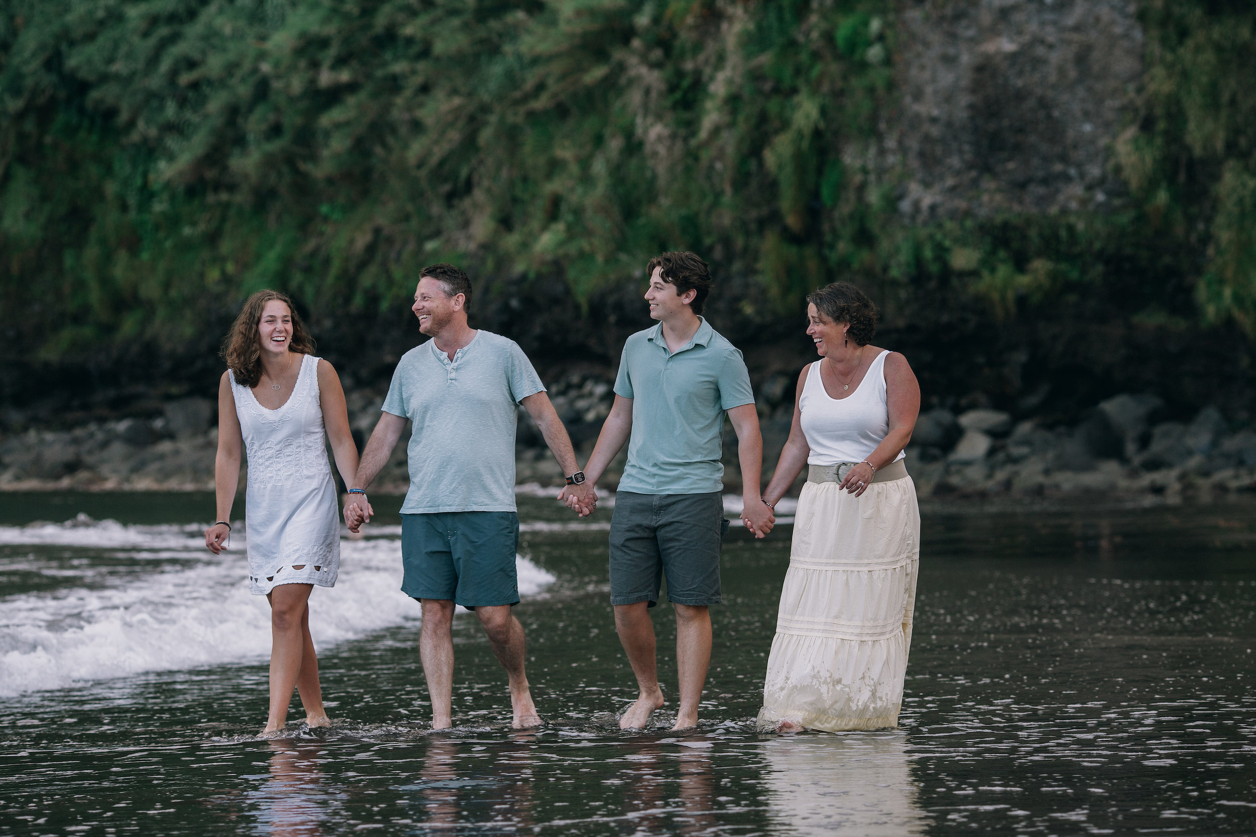 The family wading hand in hand into the shallows at Seixal, Madeira