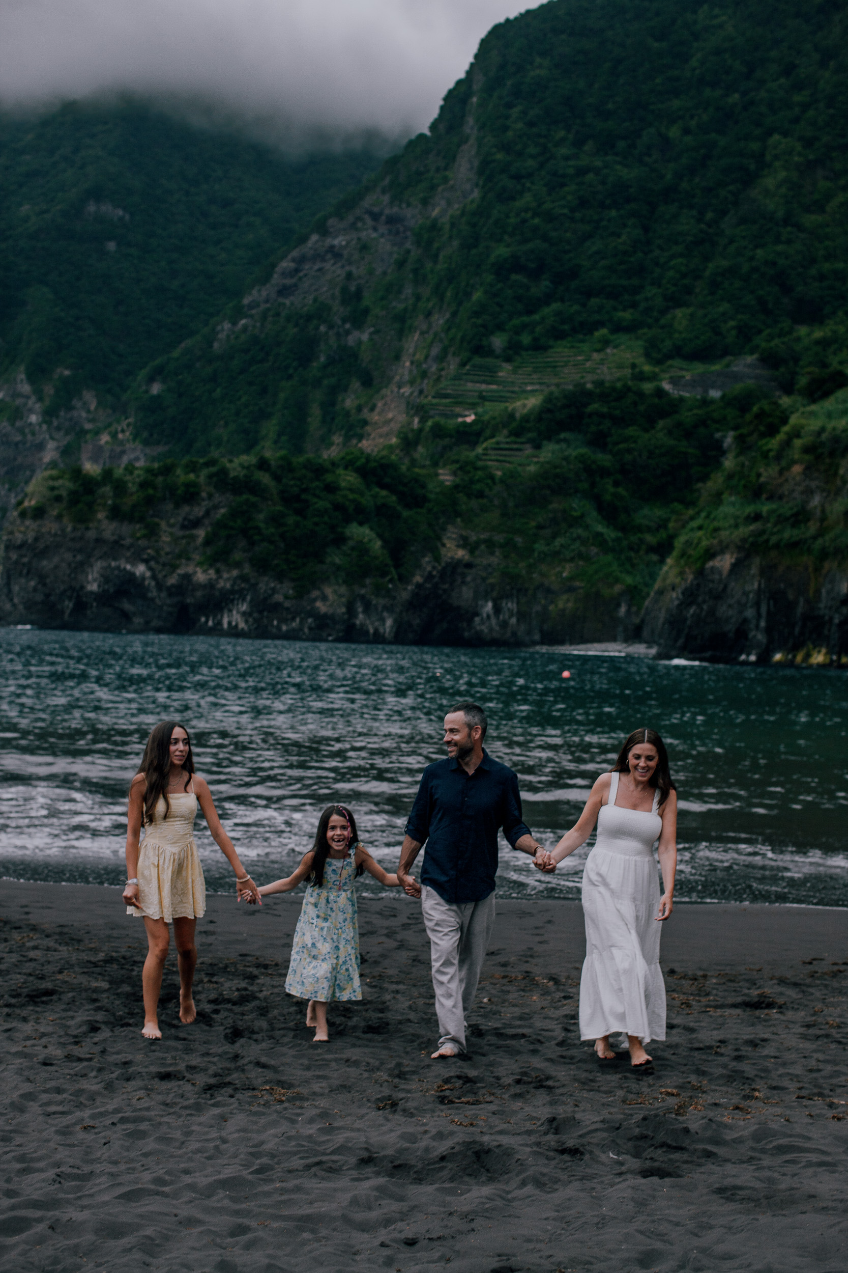 Walking together along the dark shore below the cliffs, Seixal Beach, Madeira