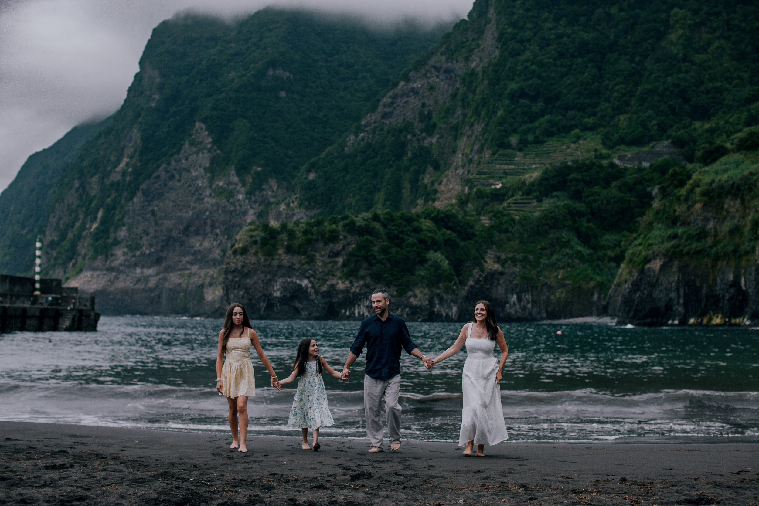 Four of them against the harbor pier and misty cliffs, Seixal Beach, Madeira