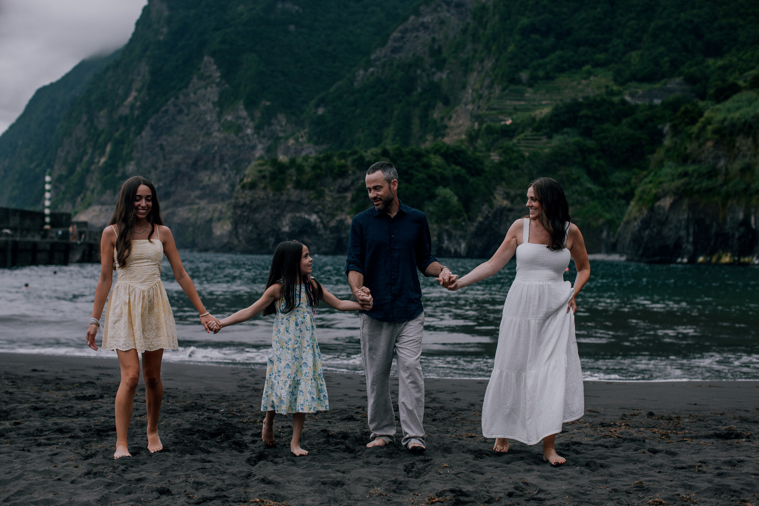 The family laughing mid-stride on the black sand, Seixal, Madeira