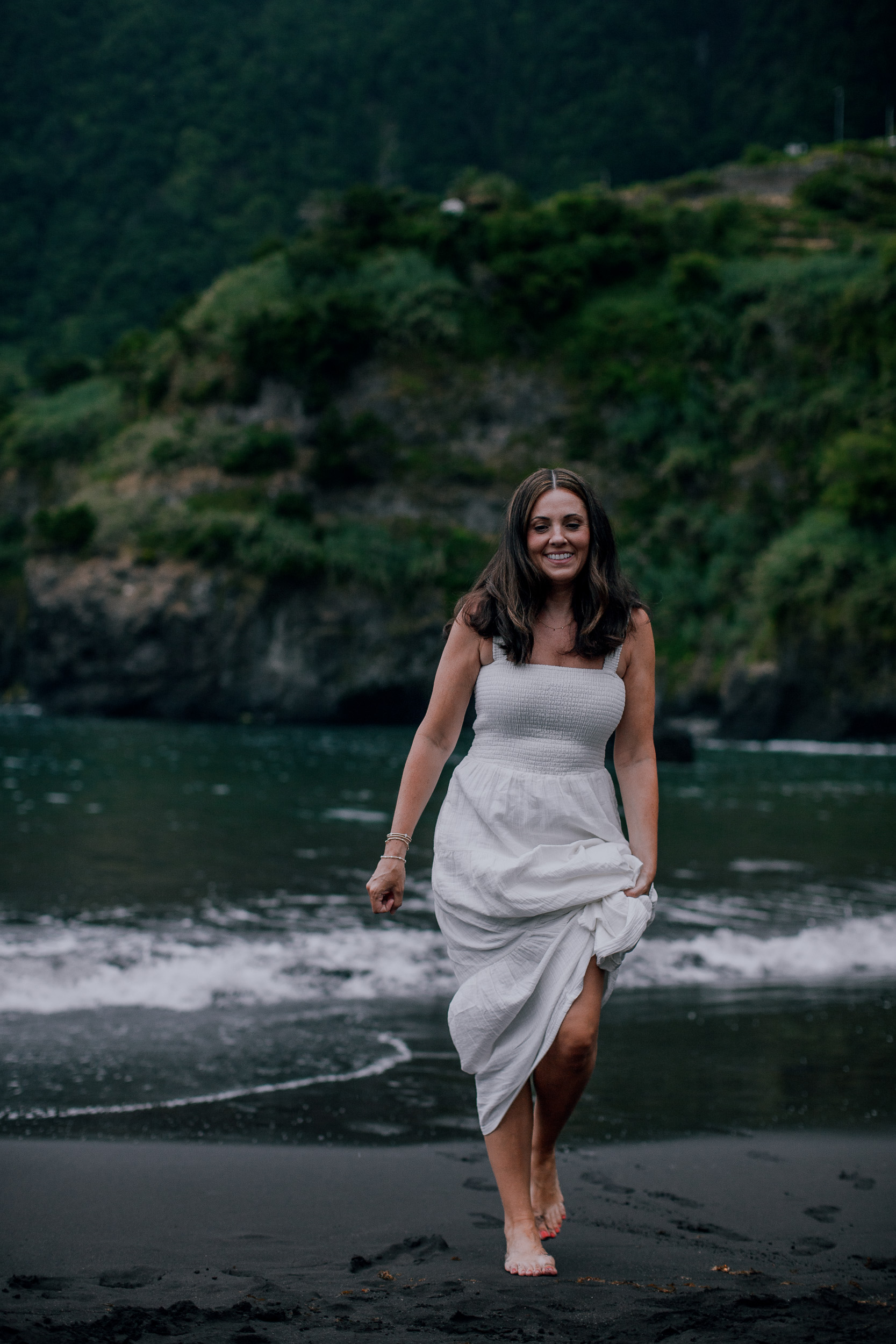 Mother walking the waterline holding her white dress, Seixal, Madeira