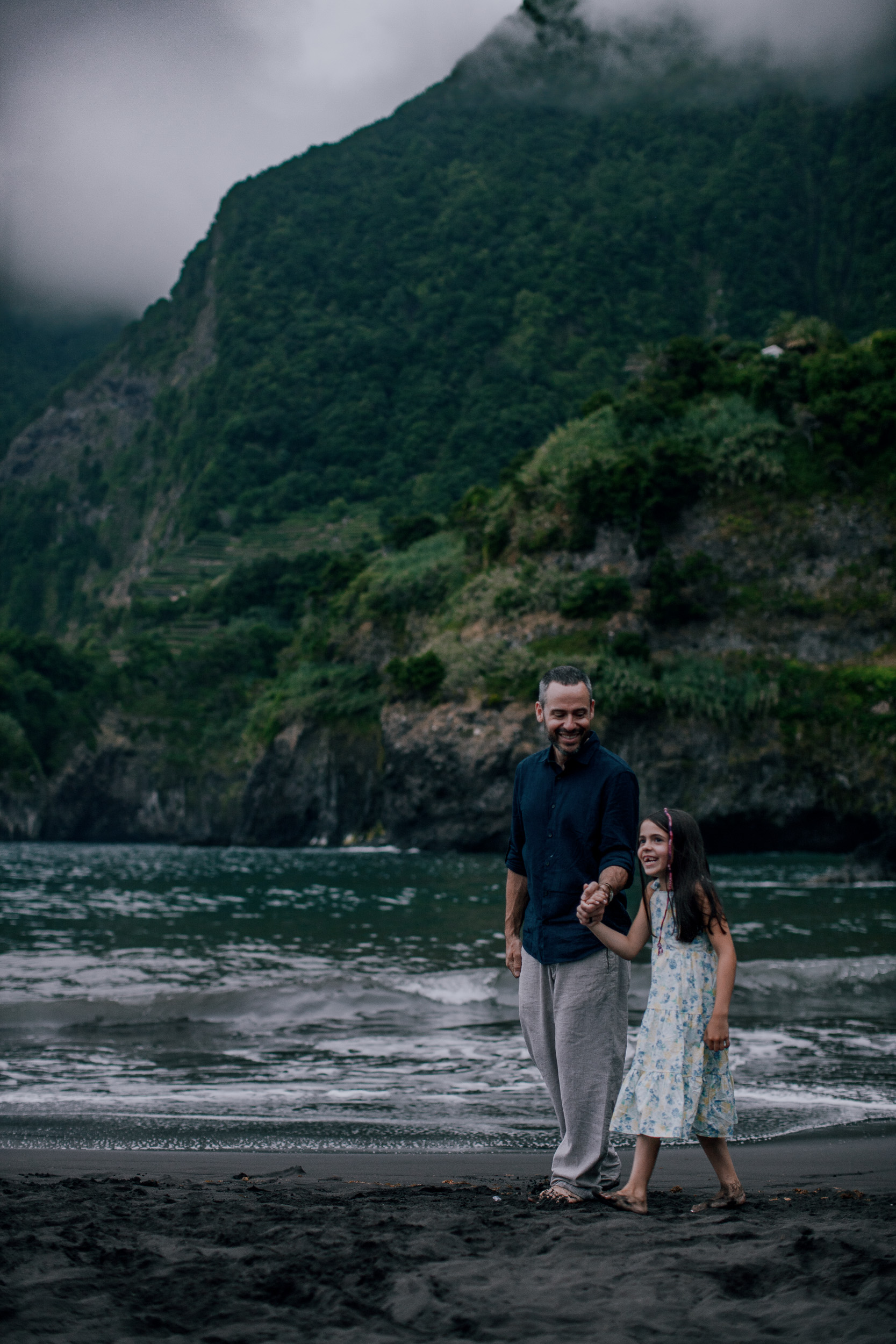 Dad and the younger daughter at the surf, cliffs above, Seixal, Madeira