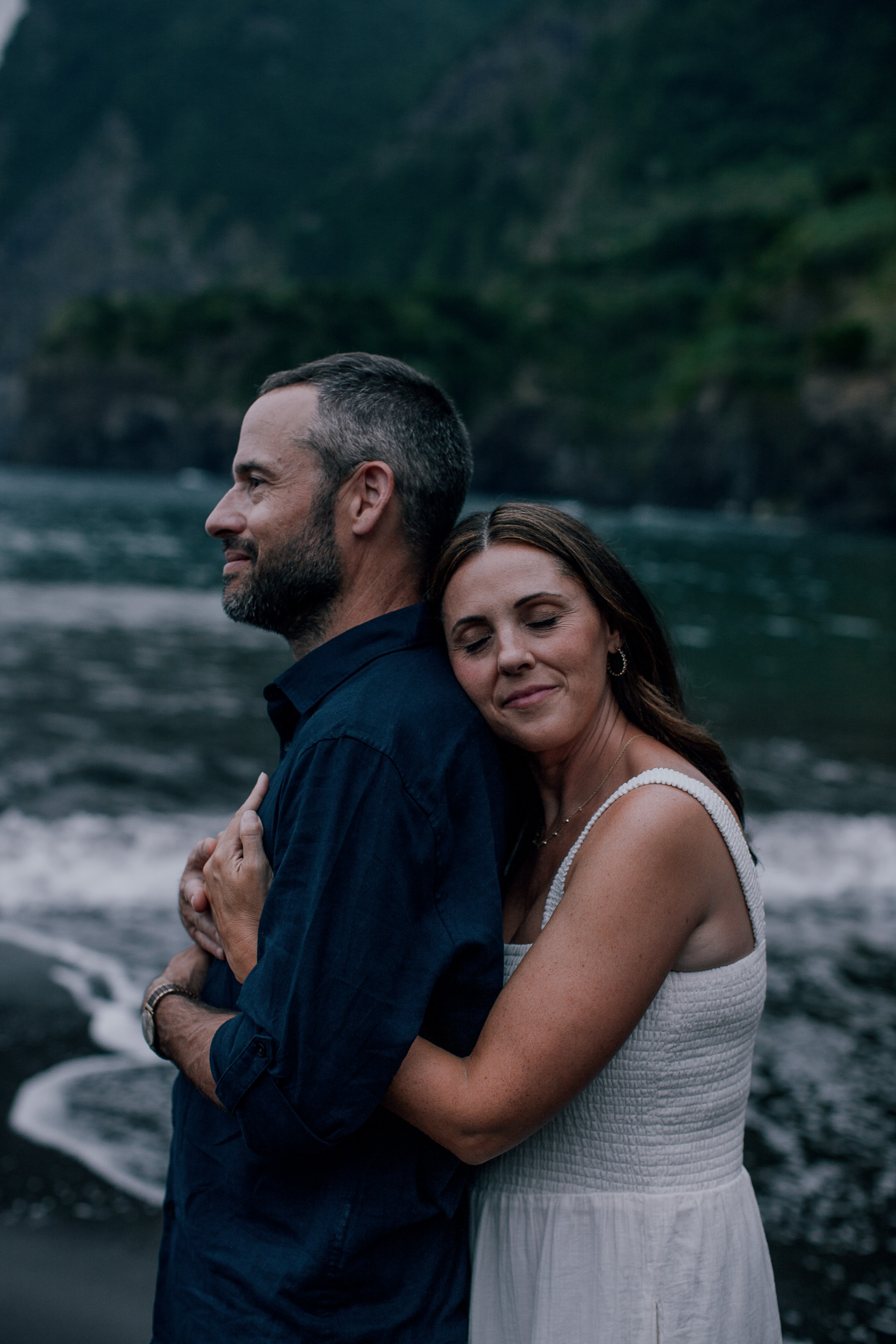 She rests her head on his shoulder by the sea, Seixal, Madeira