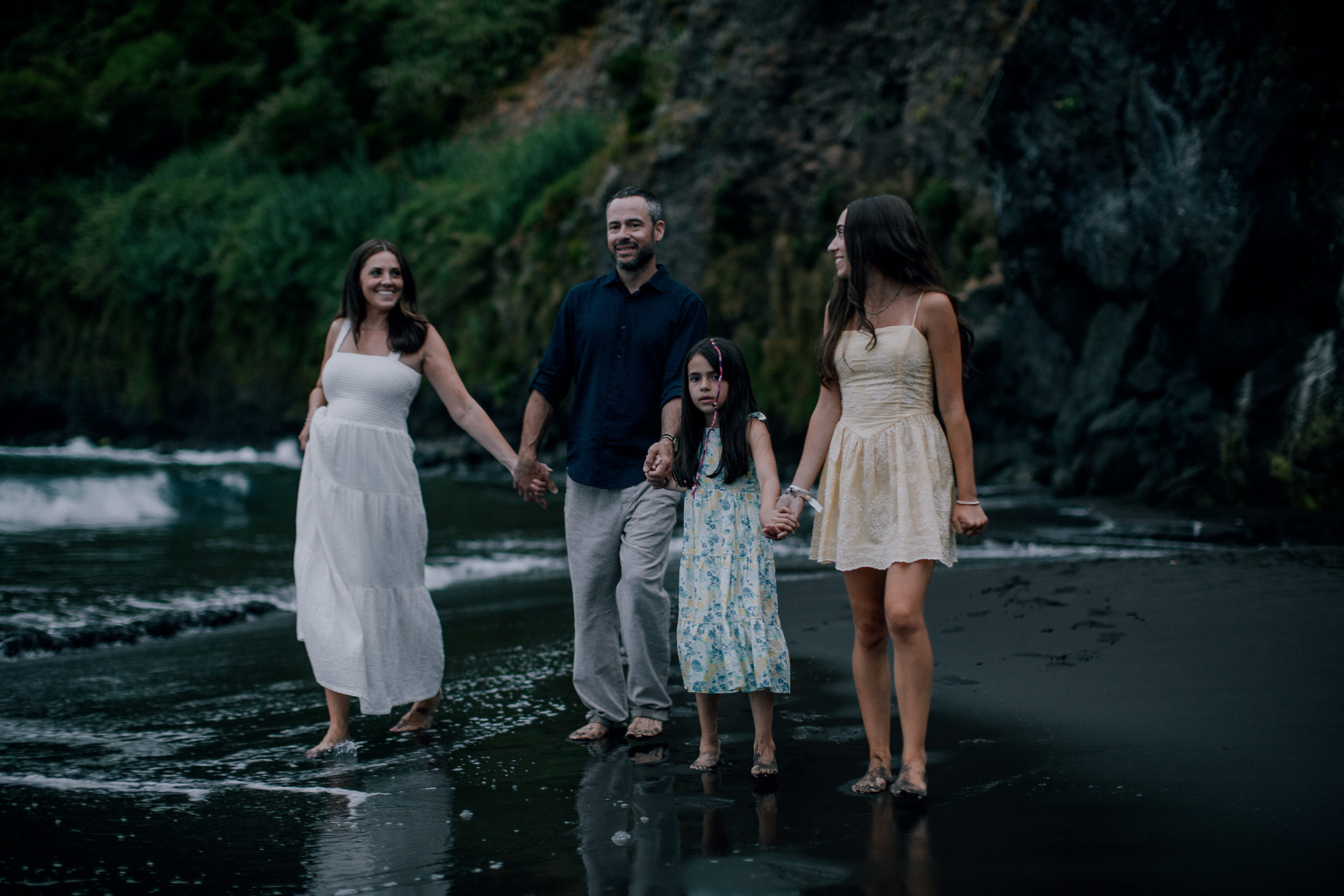 All four holding hands in the shallows at dusk, Seixal, Madeira