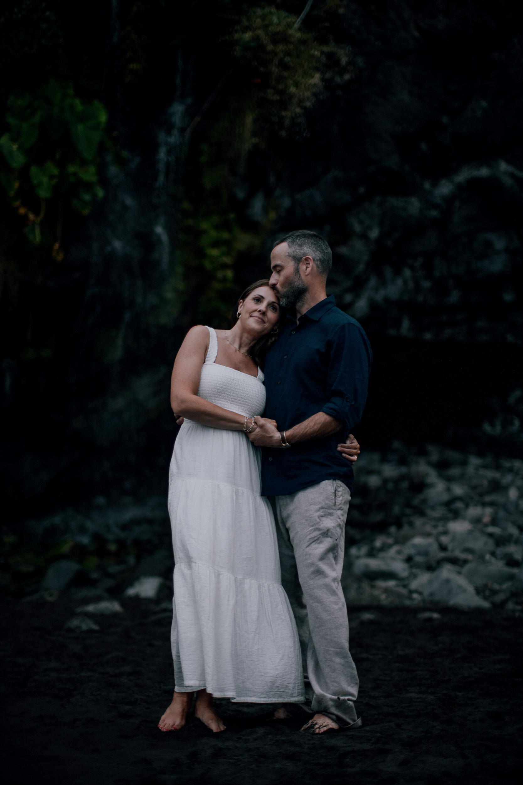 Embracing under the cliff at nightfall, Seixal Beach, Madeira
