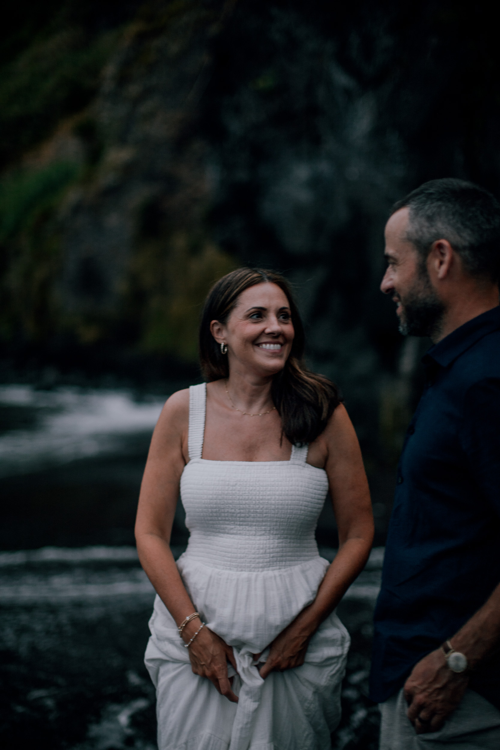 Laughing at each other at dusk, cliffs black behind, Seixal, Madeira