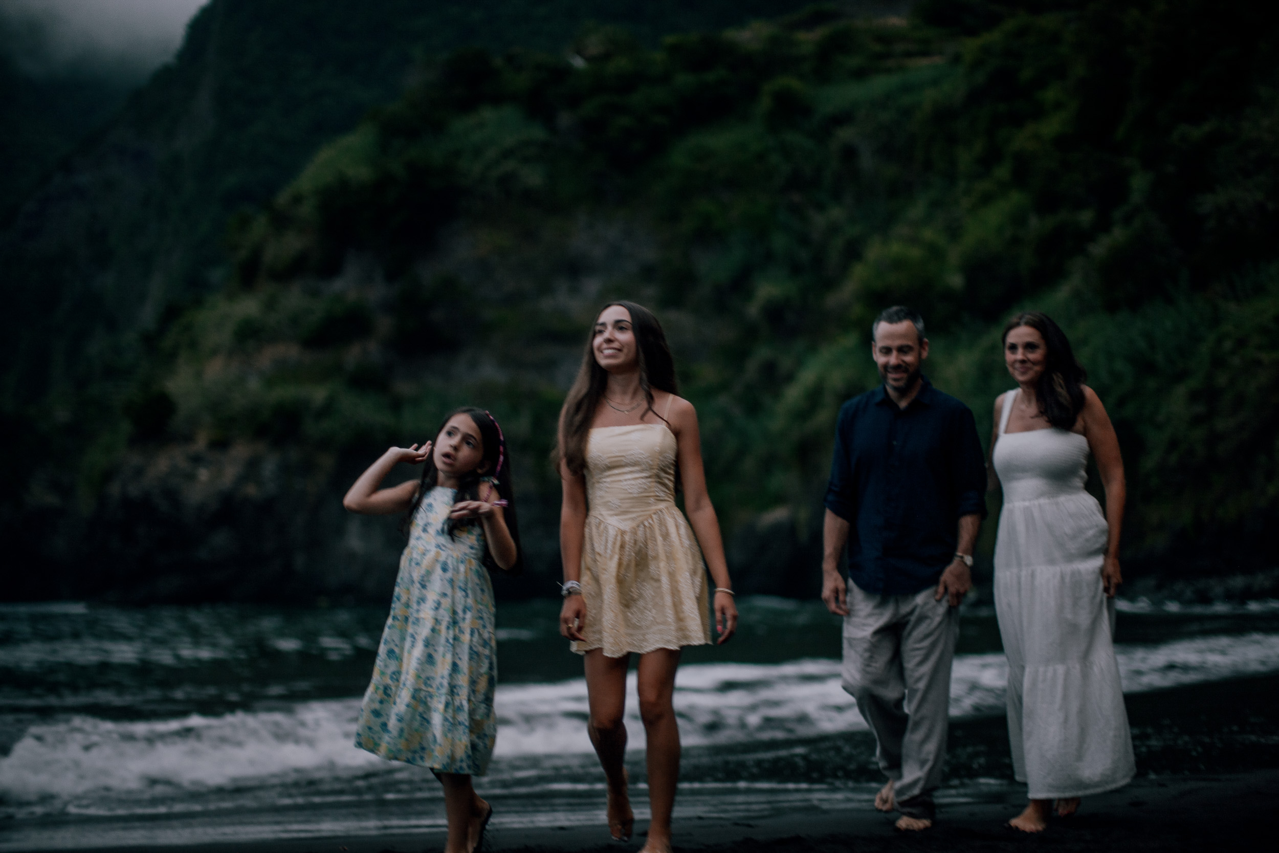 The daughters leading the way along the dark shore, Seixal, Madeira
