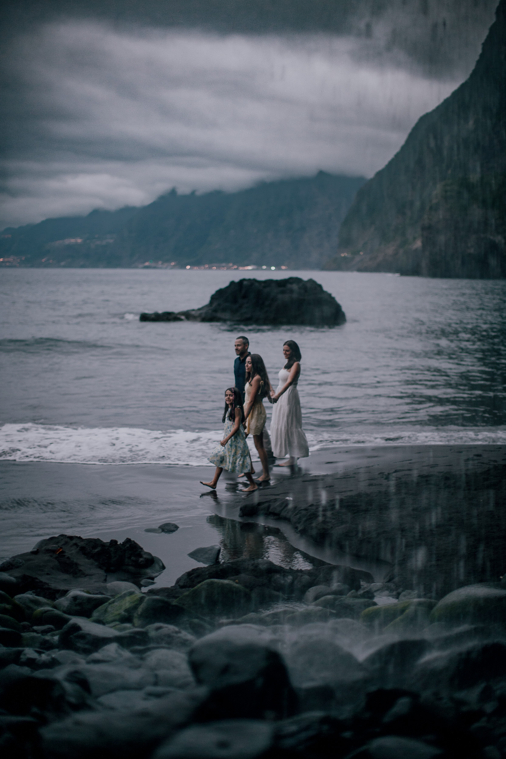 Walking the shallows past the sea stack in deep dusk, Seixal, Madeira