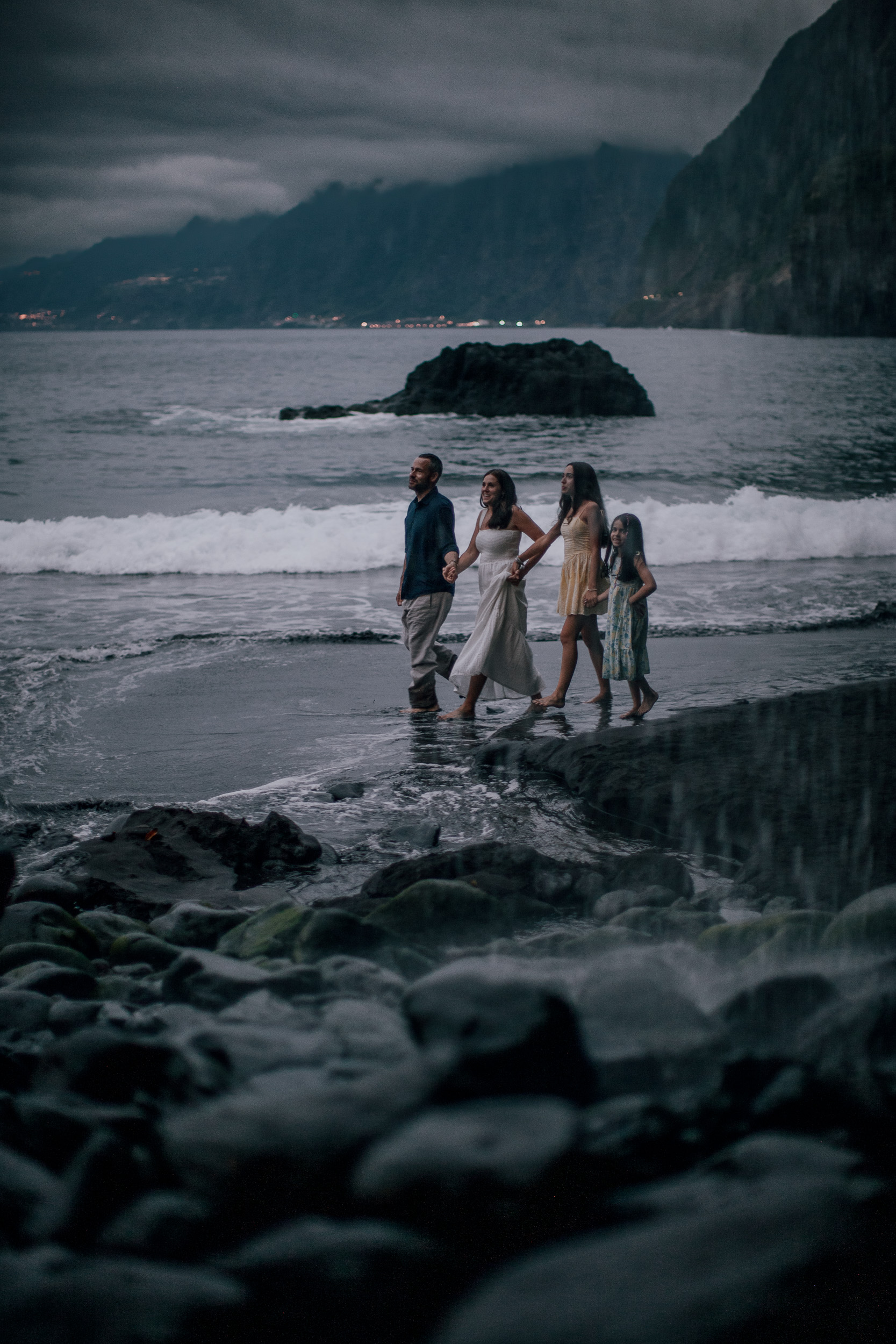 The four wading hand in hand at blue hour, Seixal Beach, Madeira