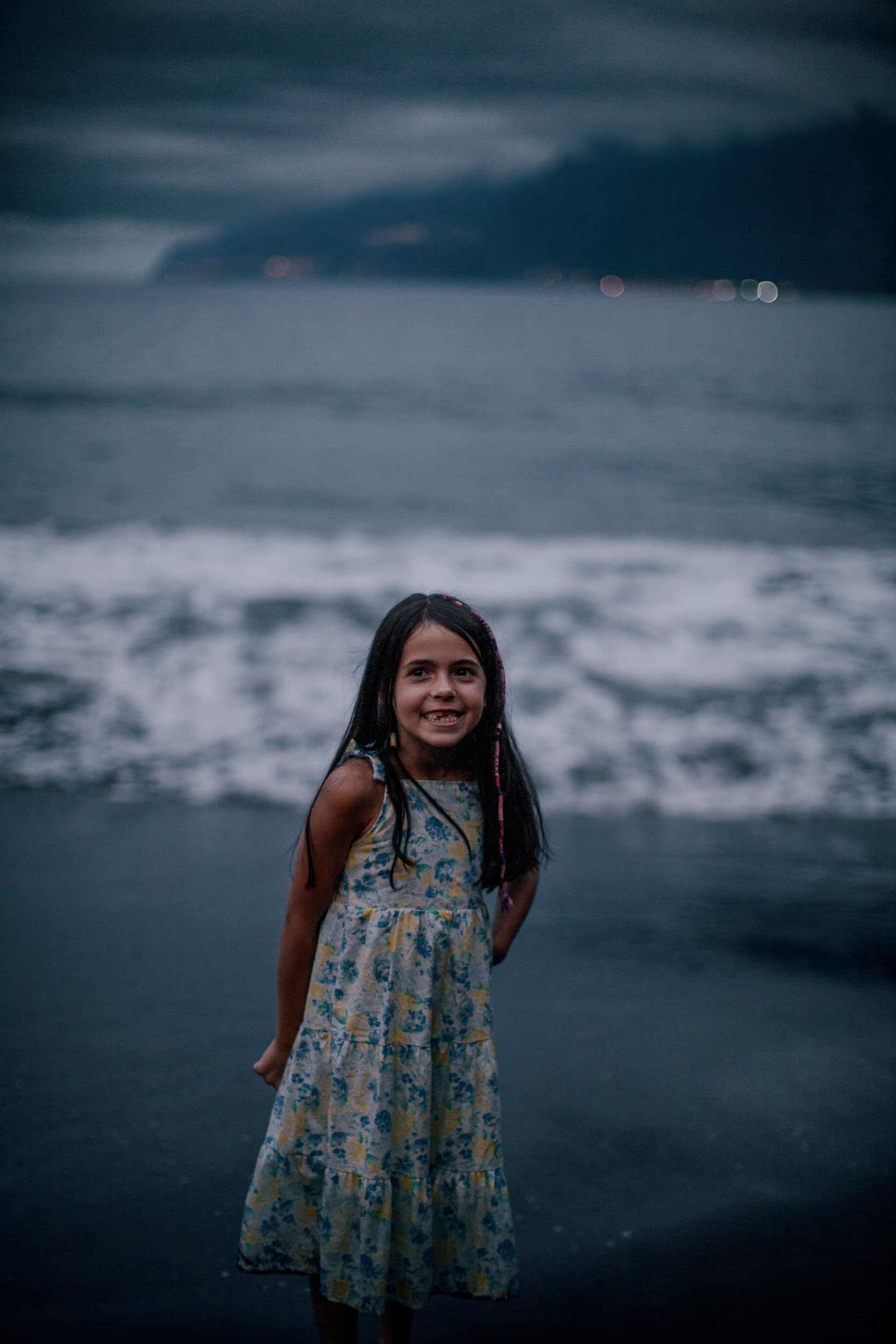 The younger daughter smiling in the deep dusk at Seixal, Madeira