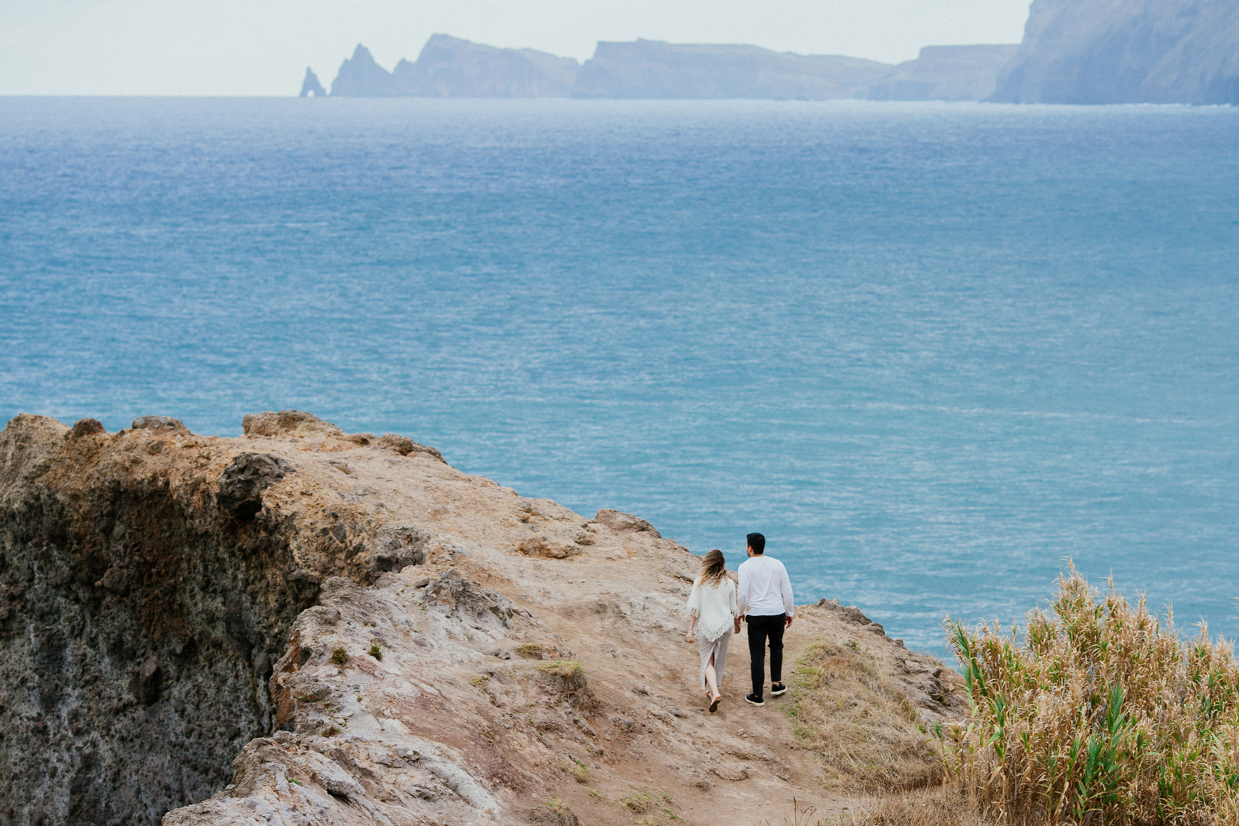Lucas and Isabela walking out along the rocky ledge above the Atlantic, Miradouro do Guindaste, Madeira