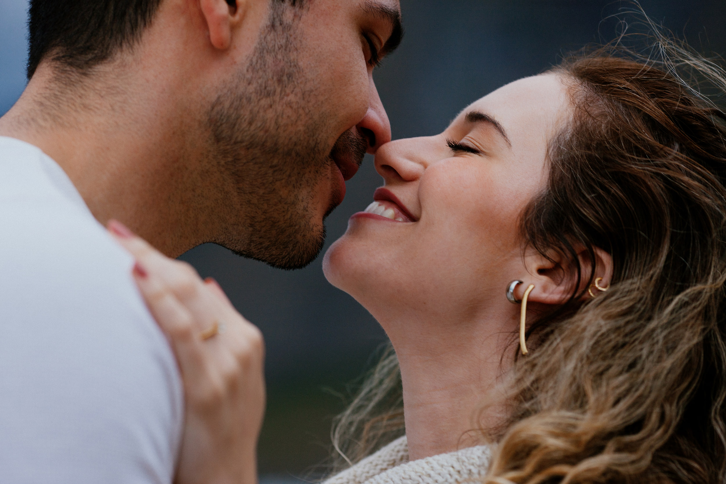 Noses touching, Isabela laughing with her eyes closed, wind in her curls, Miradouro do Guindaste, Madeira