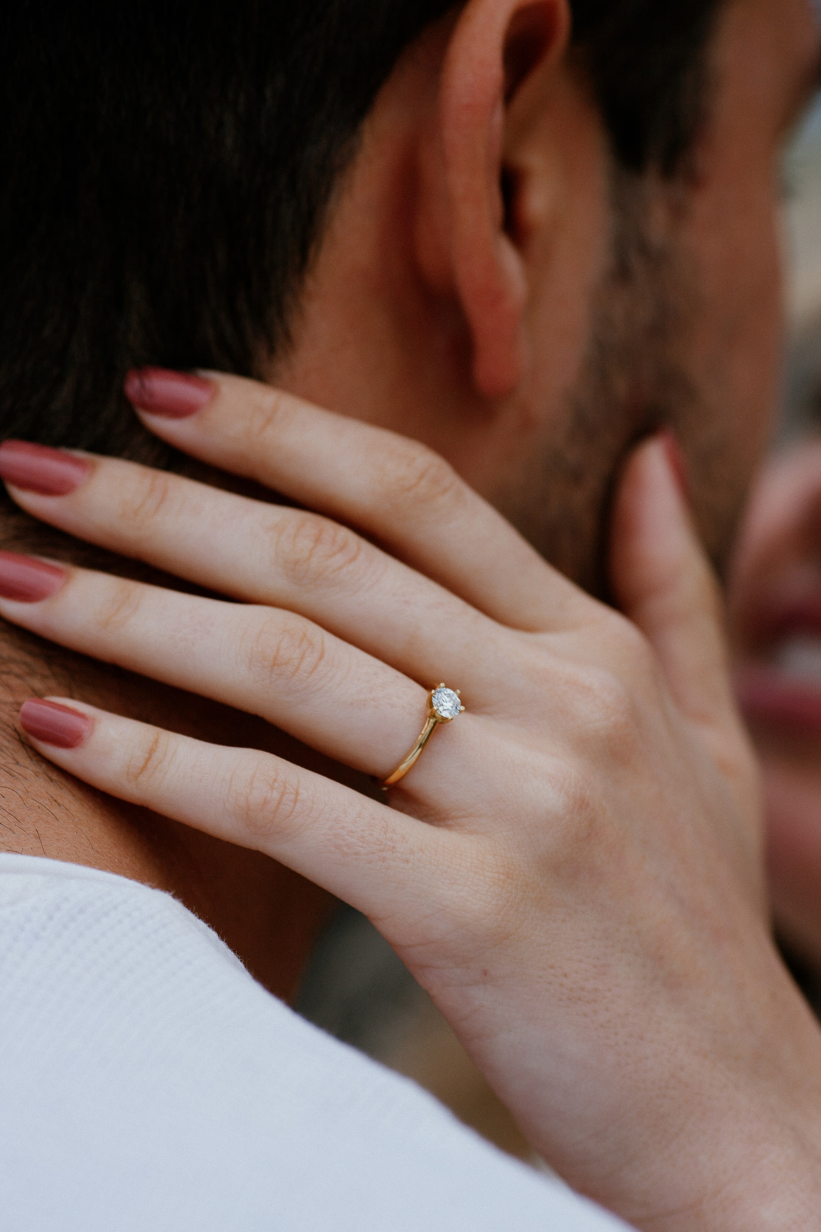 Isabela's hand with the solitaire ring resting on Lucas's neck, Miradouro do Guindaste, Madeira