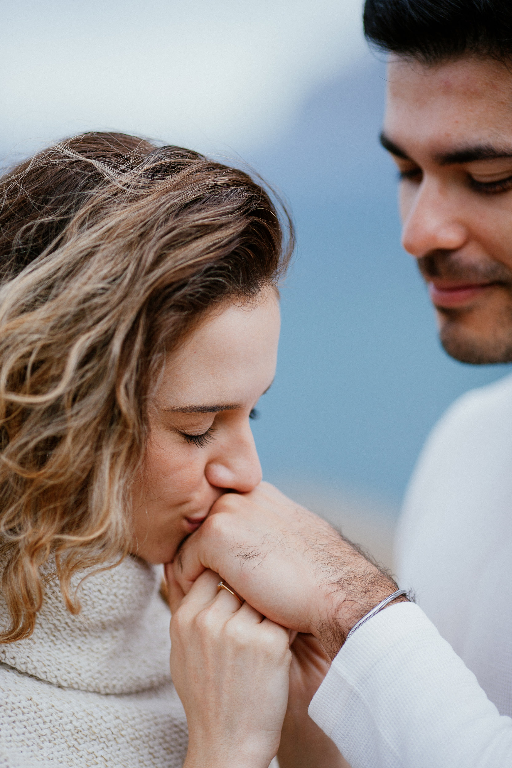 Isabela kissing Lucas's hand with her eyes closed, Miradouro do Guindaste, Madeira