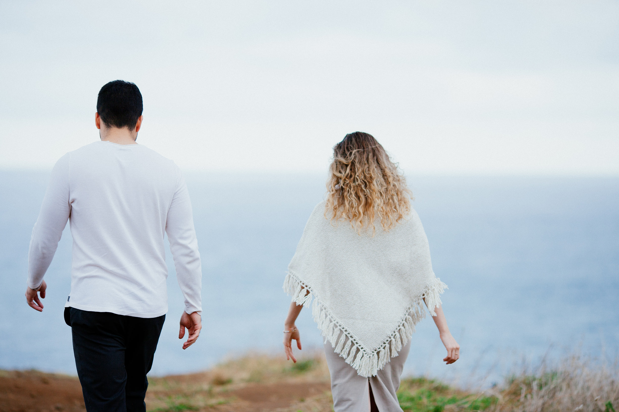 Lucas and Isabela from behind, walking toward the edge of the cliff and the open sea, Miradouro do Guindaste, Madeira