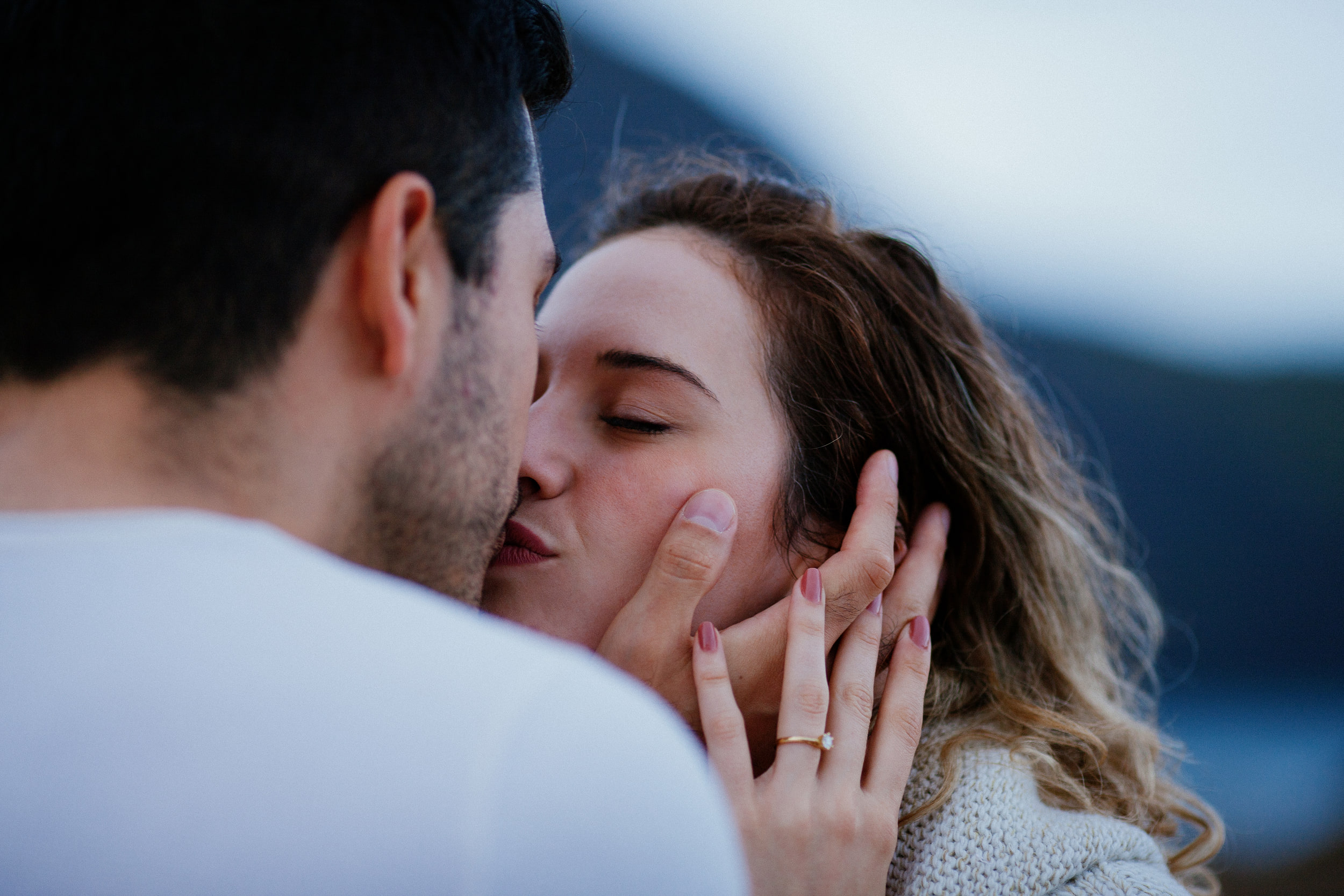 Lucas kissing Isabela, her ring hand on his cheek, Miradouro do Guindaste, Madeira